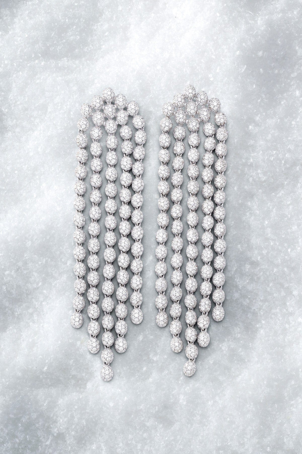 APM MONACO pave cascade necklace in silver on a textured gray surface