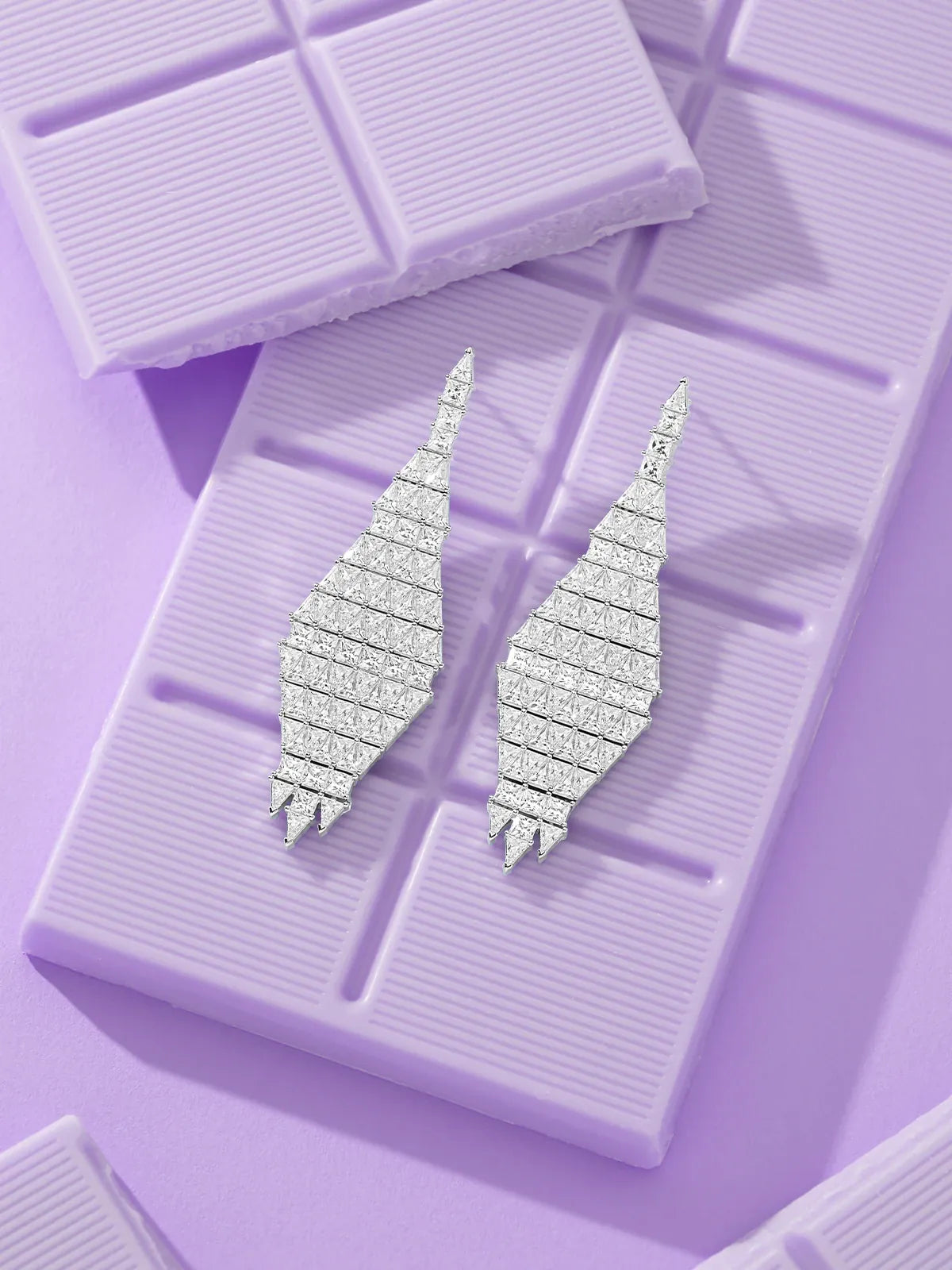APM Monaco Art Deco Silver earrings on a purple chocolate bar