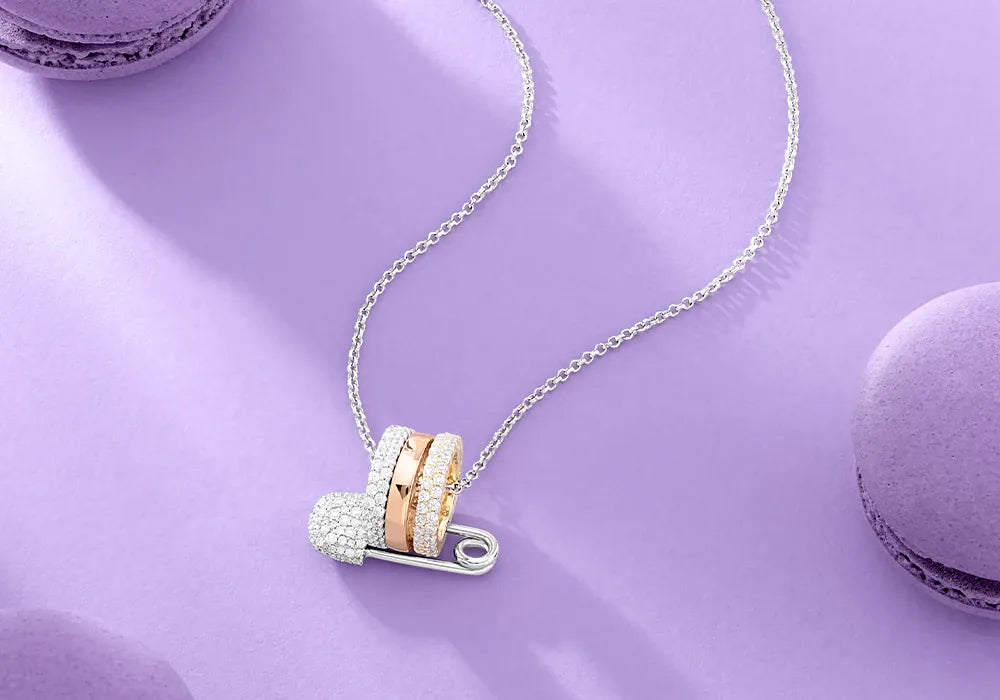 APM Monaco Tricolor safety pin necklaces on lilac background