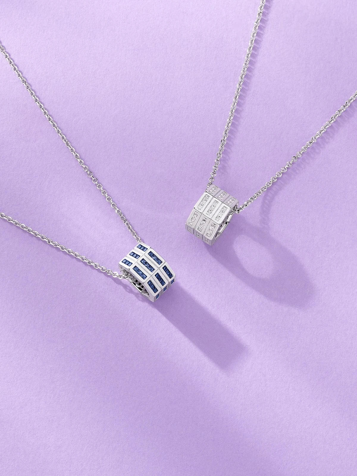 APM Monaco silver adjustable necklaces with geometric pendants on a purple background
