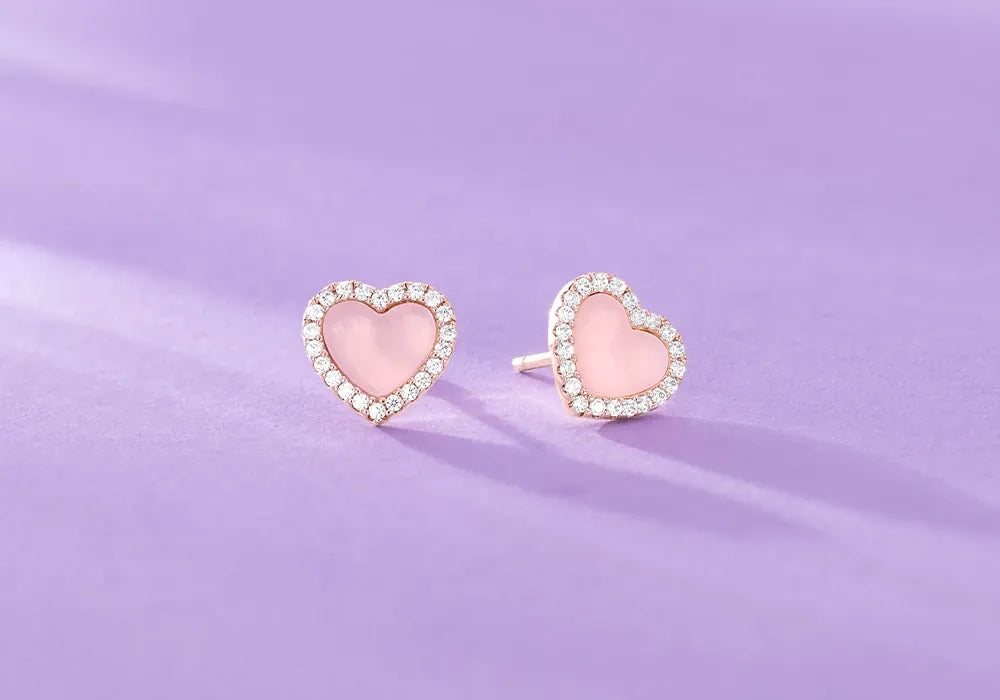 APM Monaco Heart-shaped pink earrings on a purple background