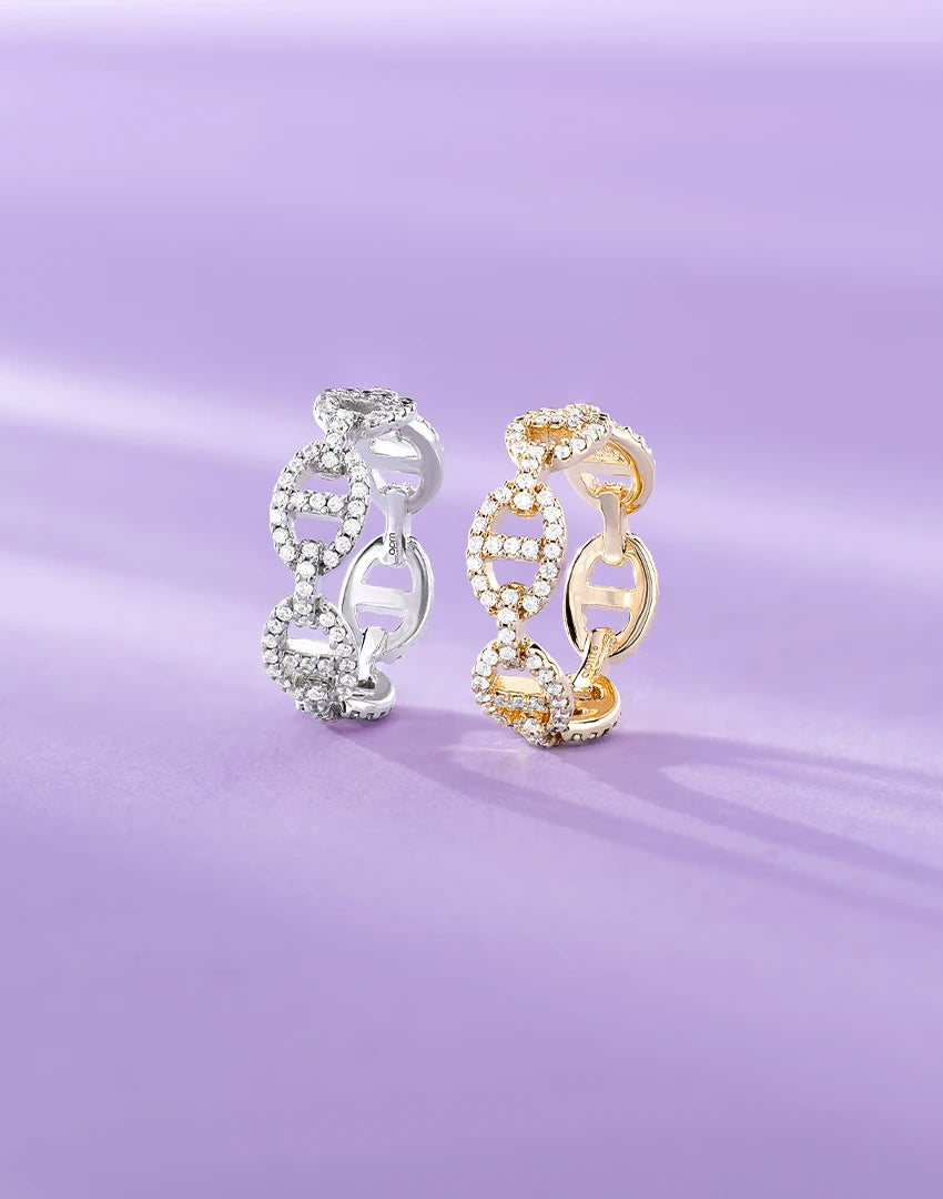 Silver and gold APM Monaco yacht club rings on a purple background