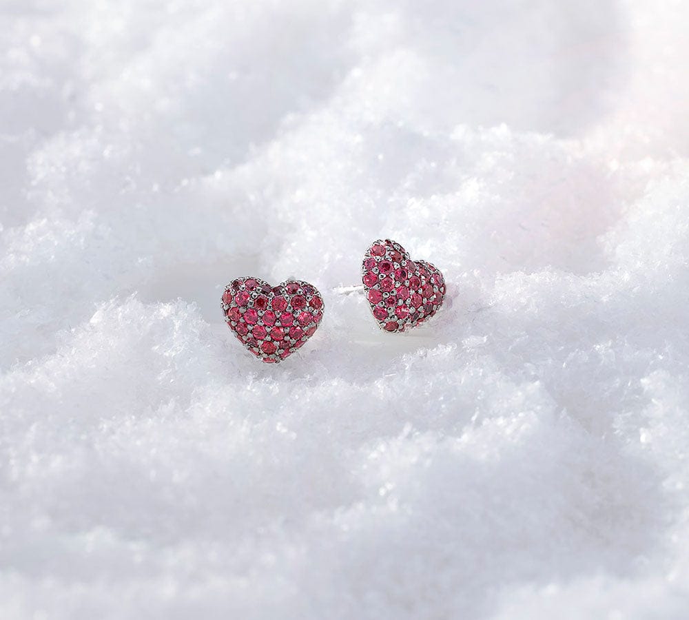 APM MONACO heart-shaped earrings with red stones on a white background