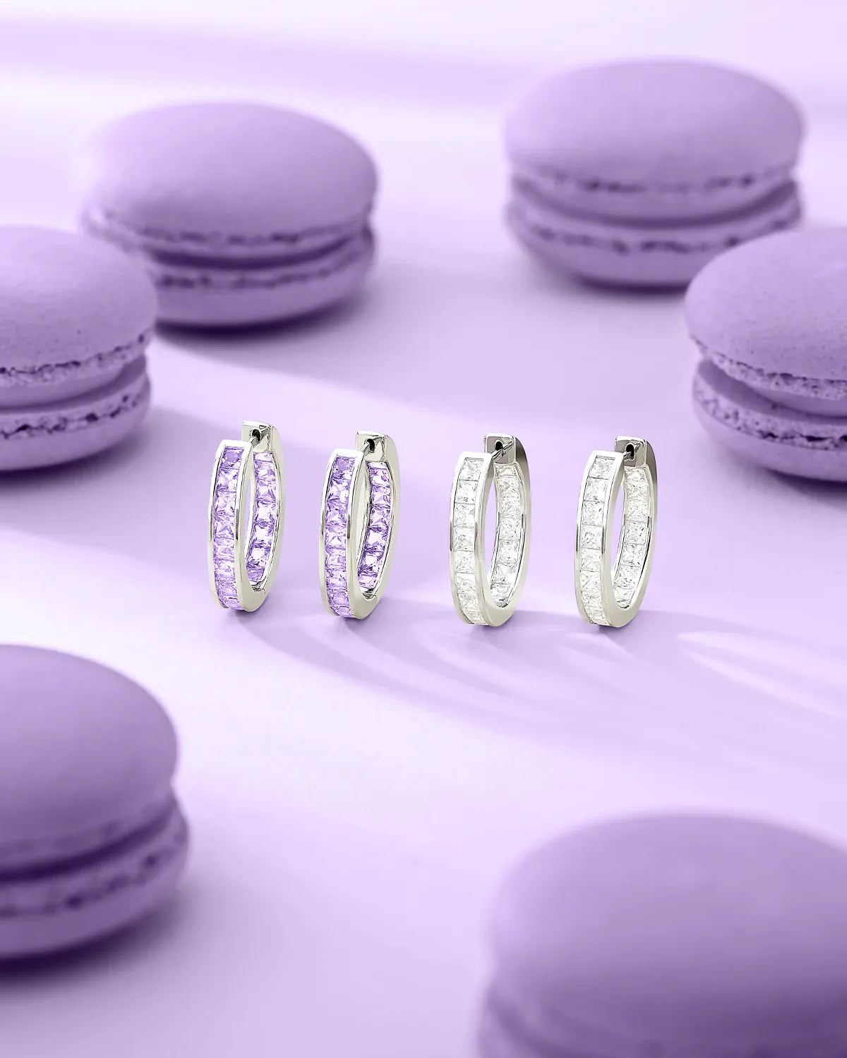 APM Monaco Lumiere hoop earrings on a purple surface with macarons