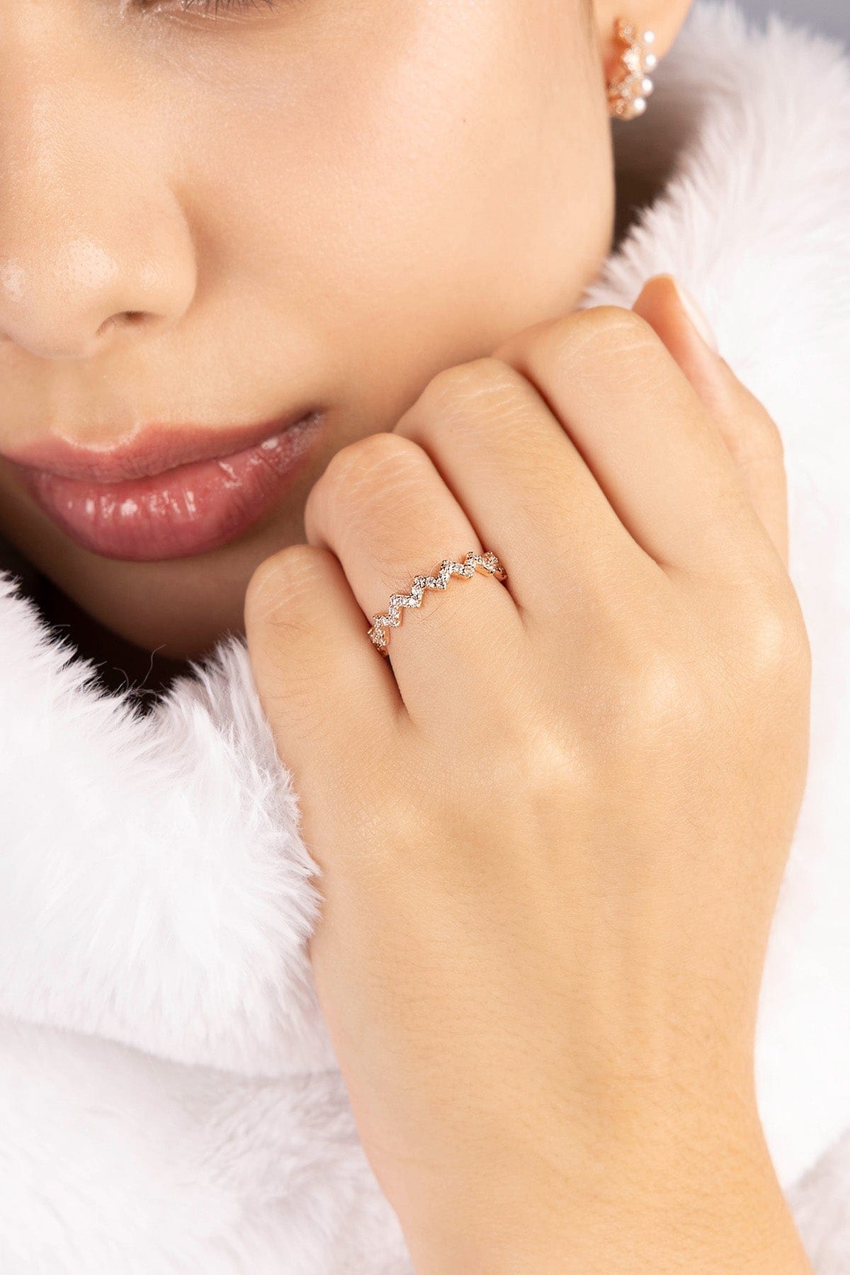 Close-up of a hand wearing a zirconia stones ring with a soft focus background