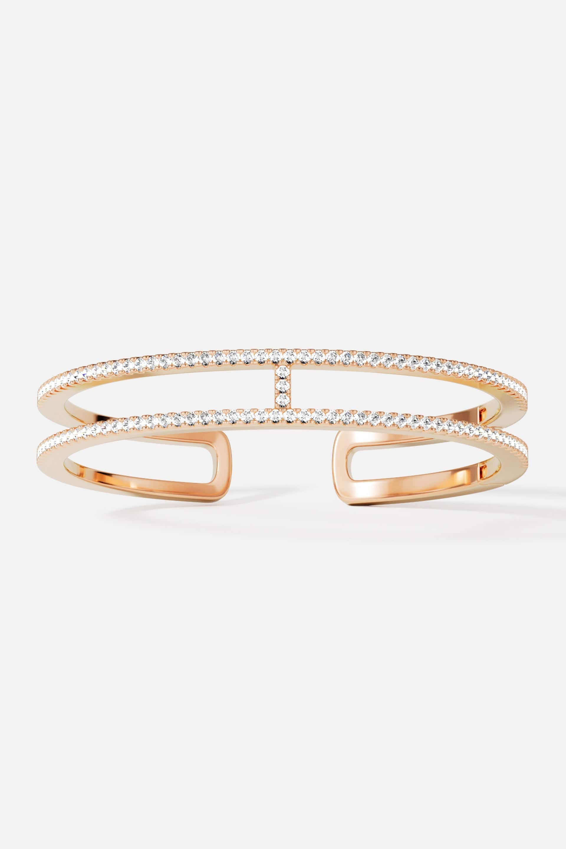 Bracelets APM Monaco, yellow gold-tone double-line pavé cuff bracelet with diamonds.
