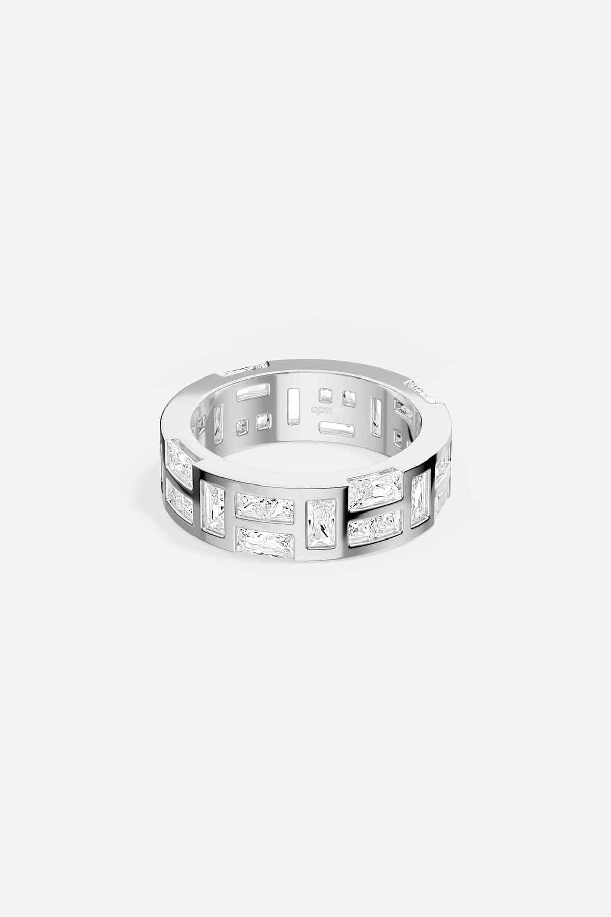 Silver-tone ring with embedded stones on a white background