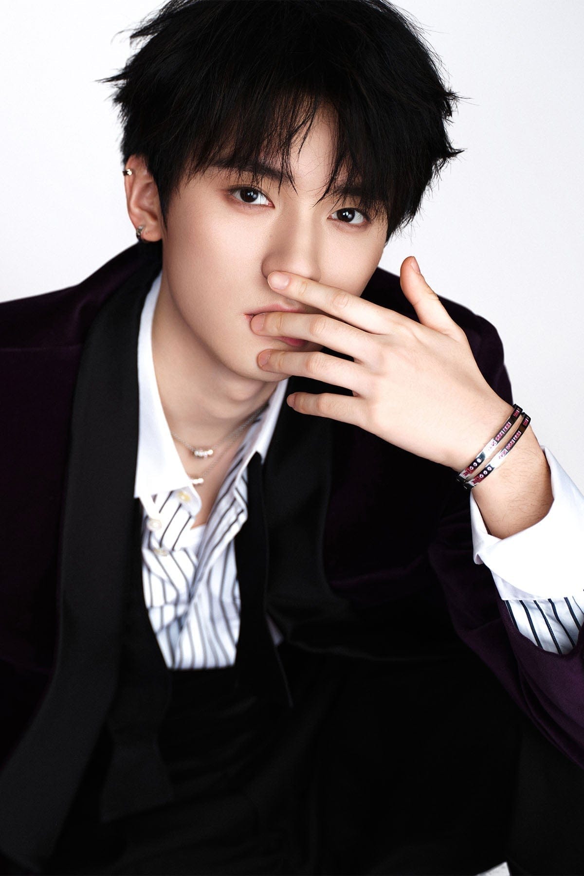 Model posing with hand on face with bangles