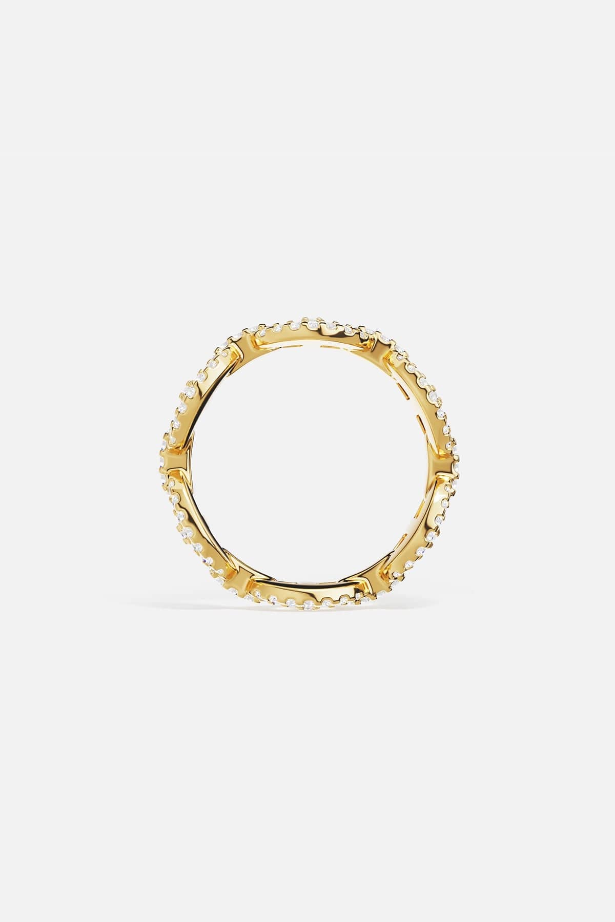 Gold ring with white cubic zirconia accents on a light gray background