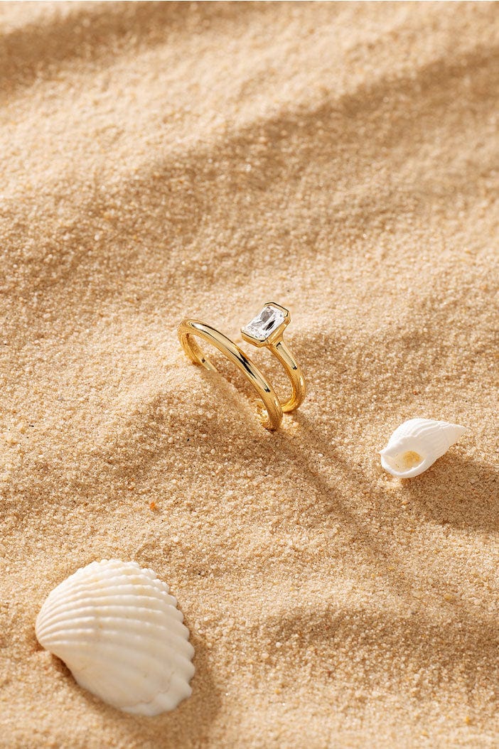 APM Monaco Twist Éclat Ring in Yellow Gold on soft sand