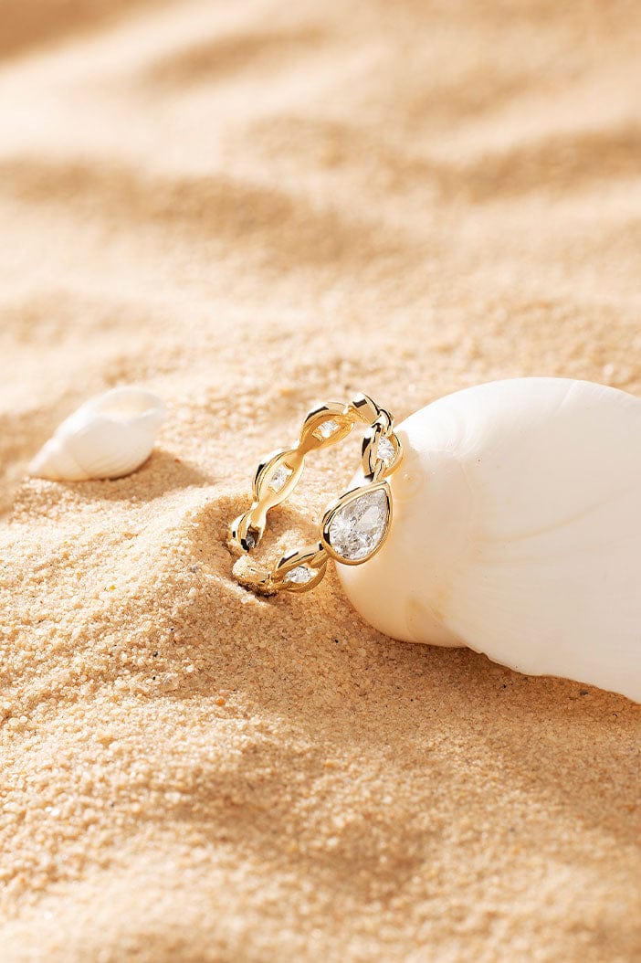 APM Monaco Éclat Chain Ring in Yellow Gold on soft beach