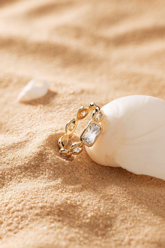 APM Monaco Éclat Chain Ring in Yellow Gold on soft sand