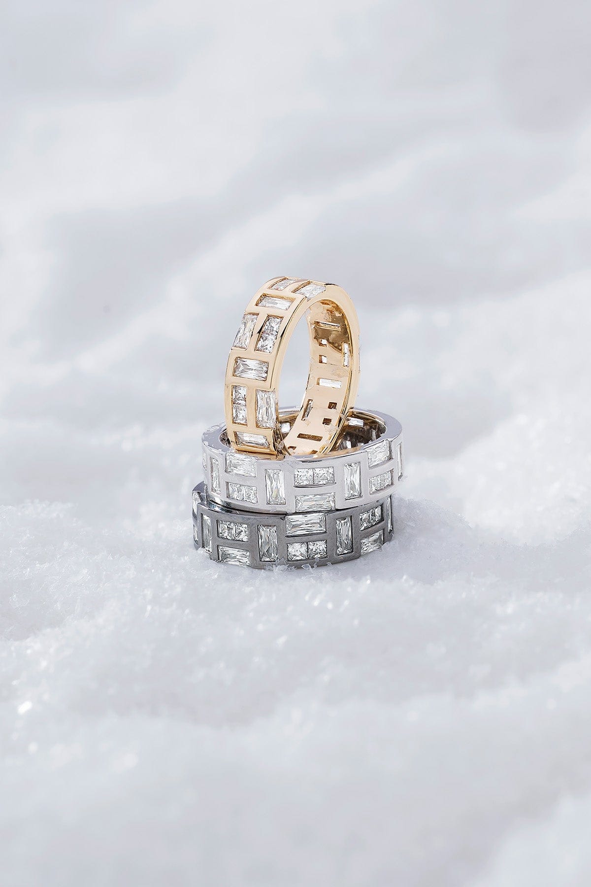 Three labyrinth rings from APM MONACO stacked on a white snowy surface