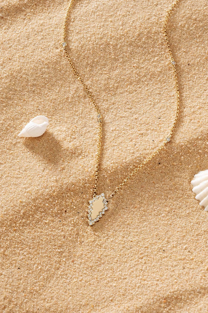 APM Monaco Éclat Adjustable Necklace in Yellow Gold placed on soft beach