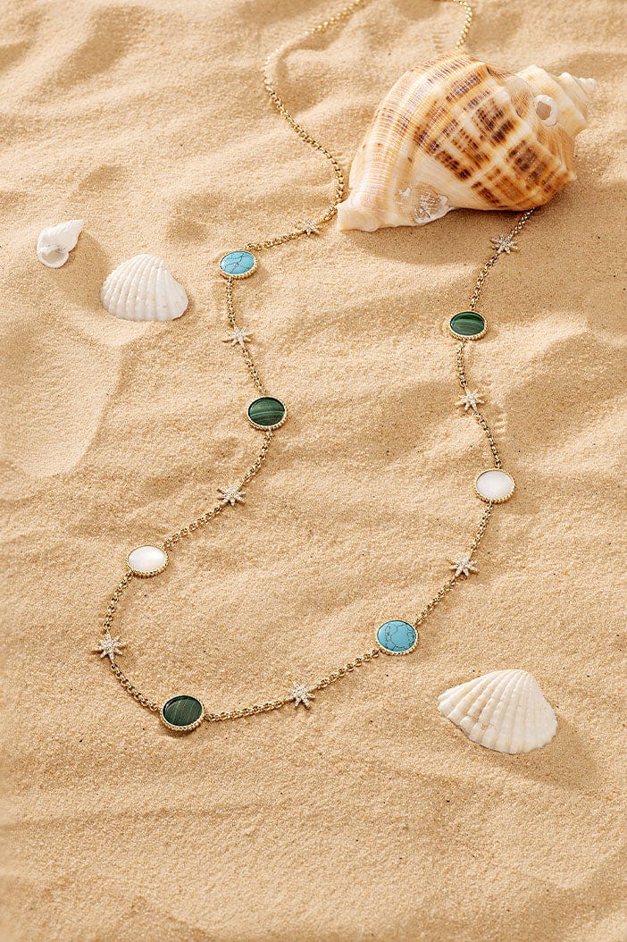 APM Monaco Météorites Adjustable Necklace in Yellow Gold placed on soft beach