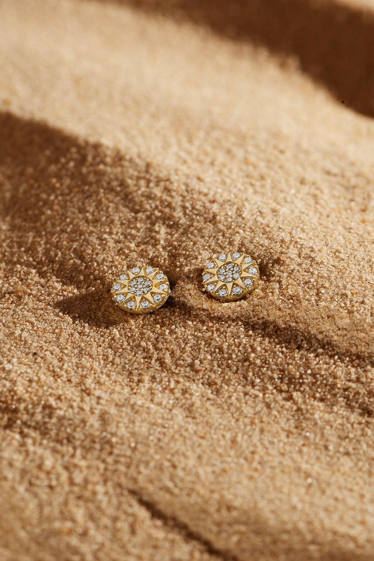 Earrings APM Monaco: two round yellow gold stud earrings with white diamonds.