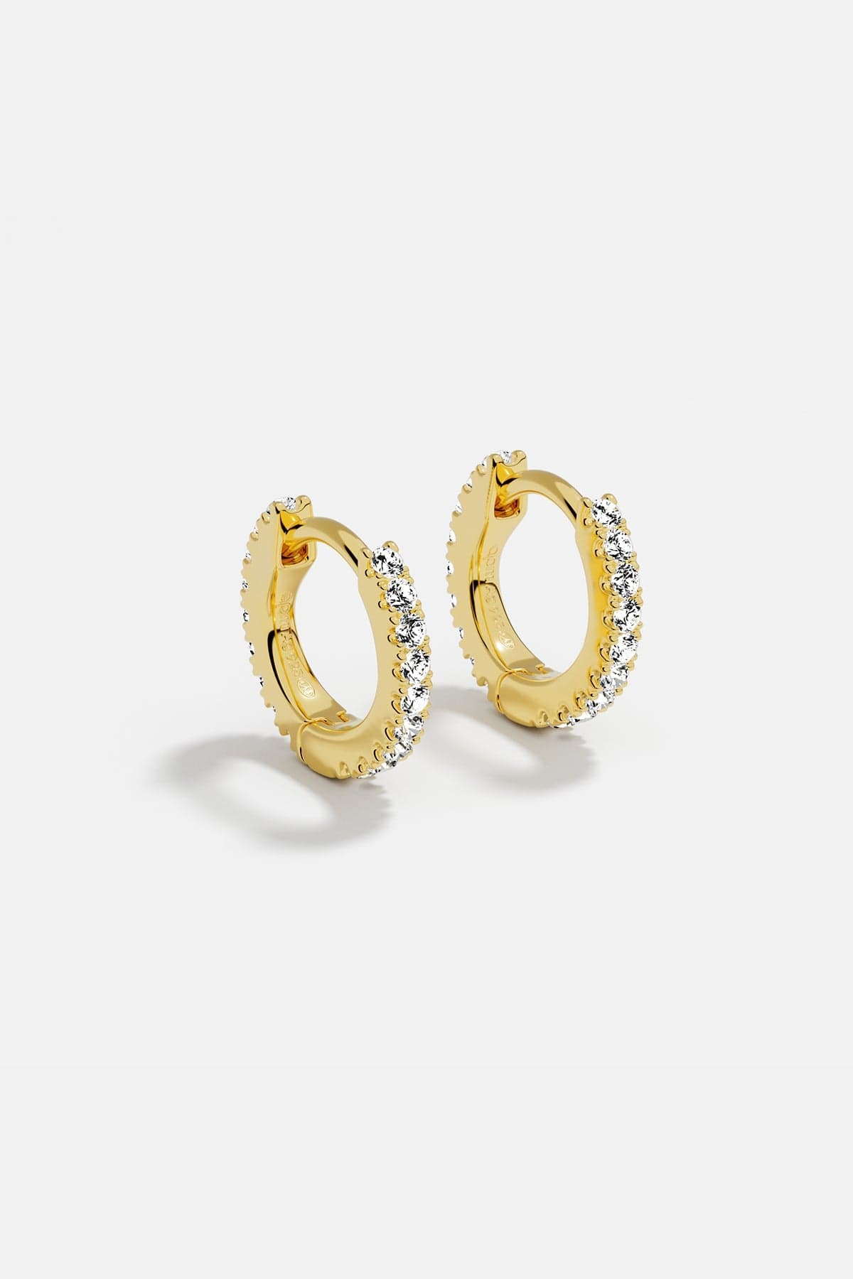 Earrings APM Monaco: yellow gold huggie hoops with white cubic zirconia.