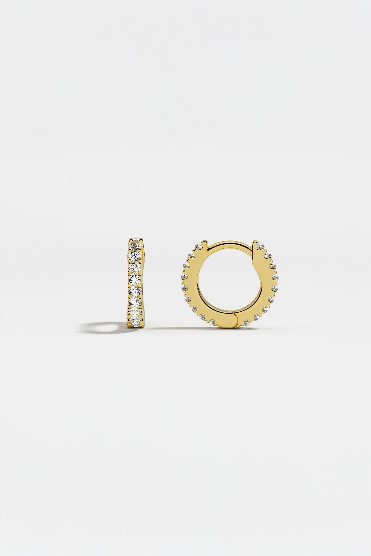 Earrings APM Monaco: yellow gold huggie hoops with white cubic zirconia.