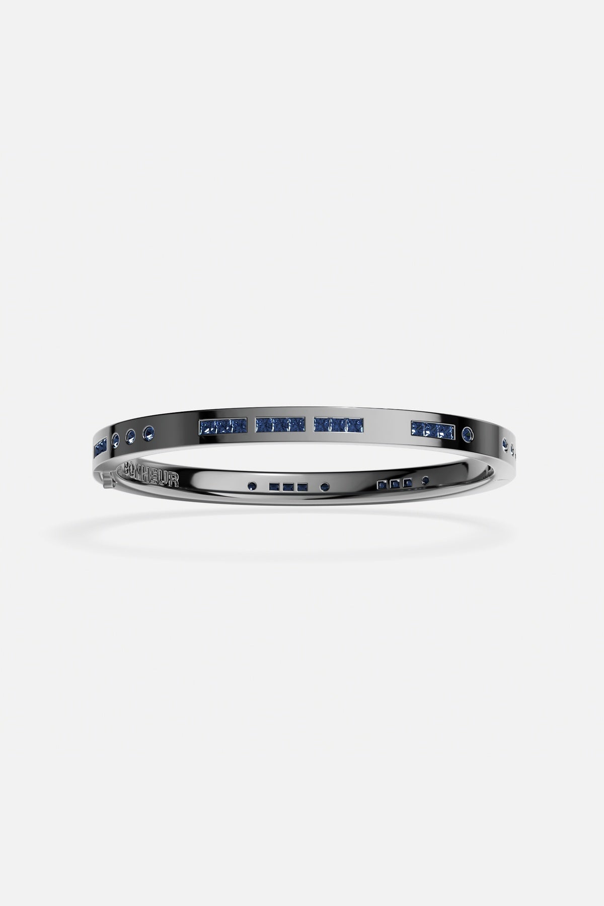 APM Bangle in rhodium finish with deep blue stones, bold and effortlessly modern.