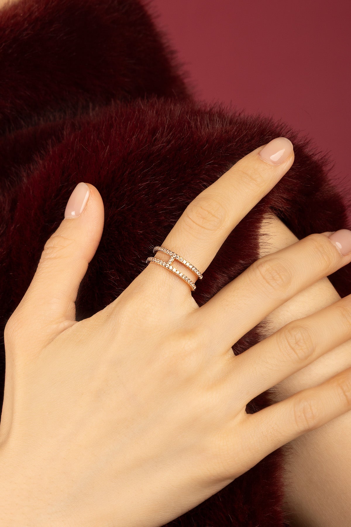Woman wearing APM double band ring, a whisper of shimmer against velvet warmth.
