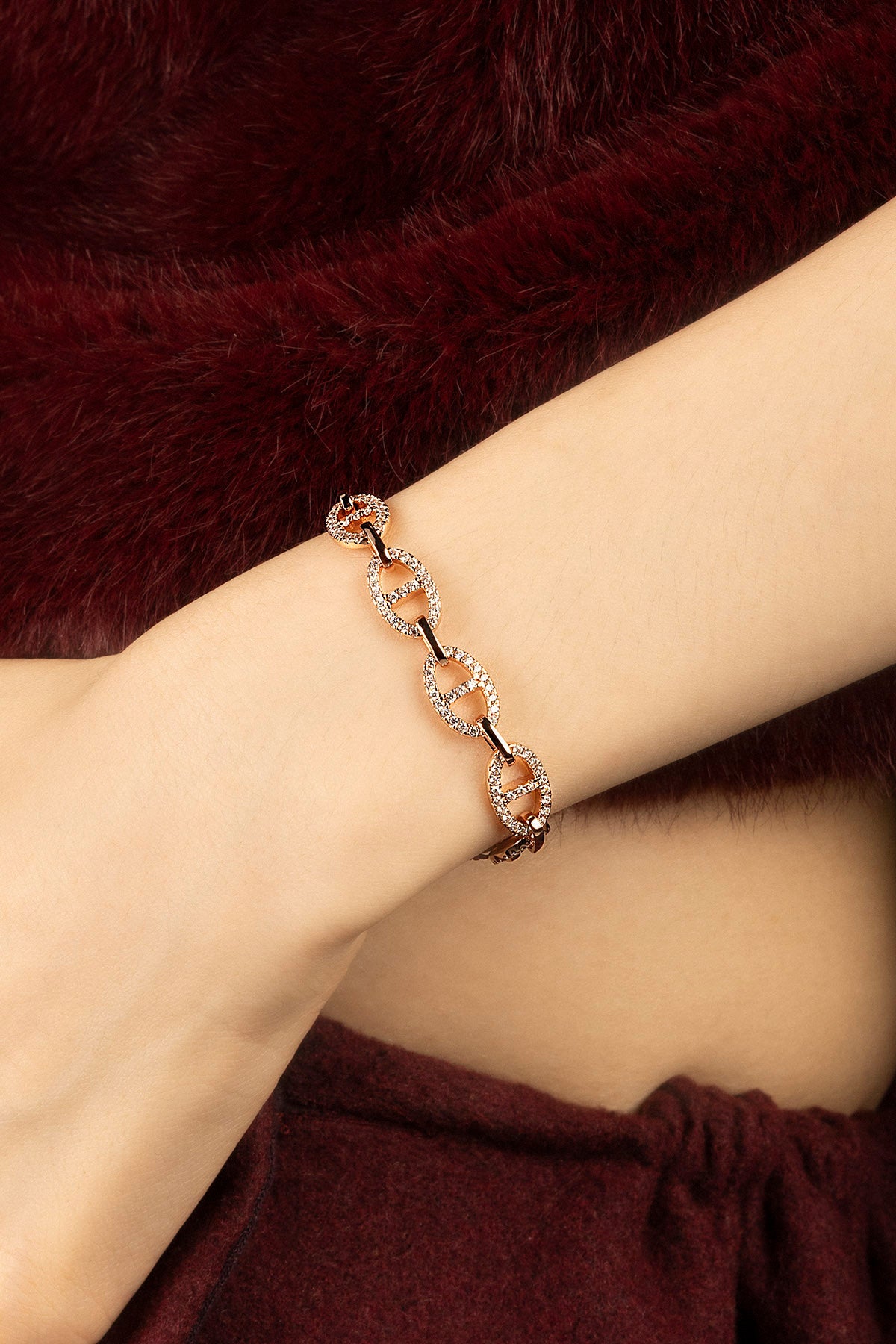 Woman wearing APM Monaco chain bracelet, a golden shimmer against winter warmth.