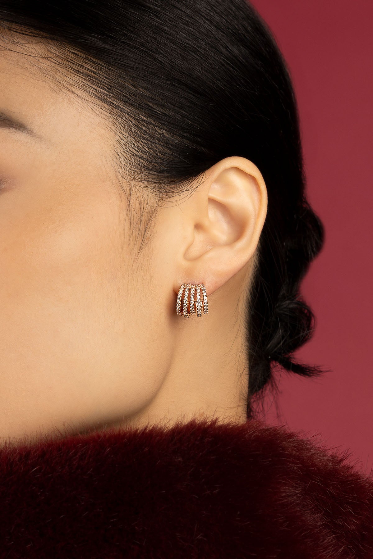 Woman wearing APM multi-row earrings, a shimmering statement of modern elegance.