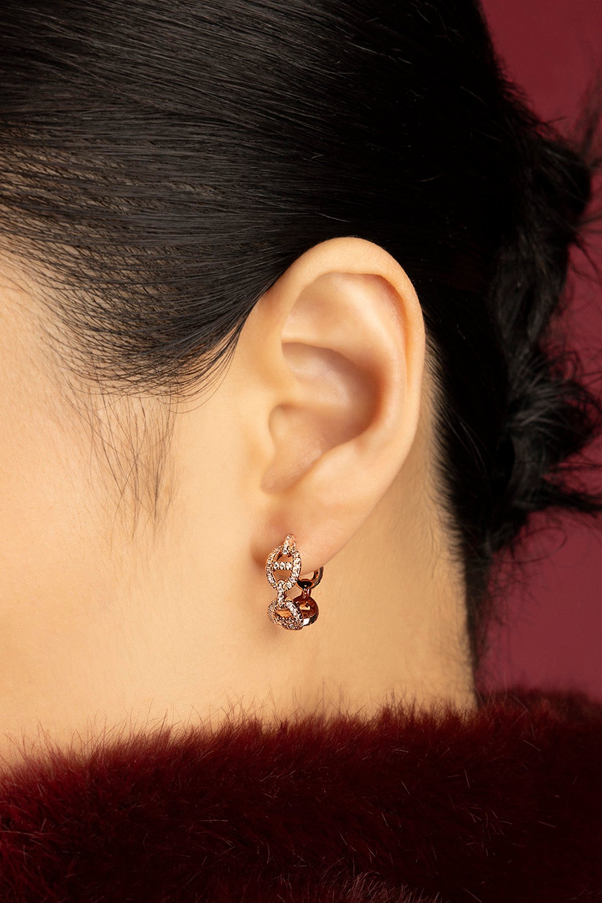 Woman wearing APM Morse Earrings, a chained whisper of rose-toned elegance.