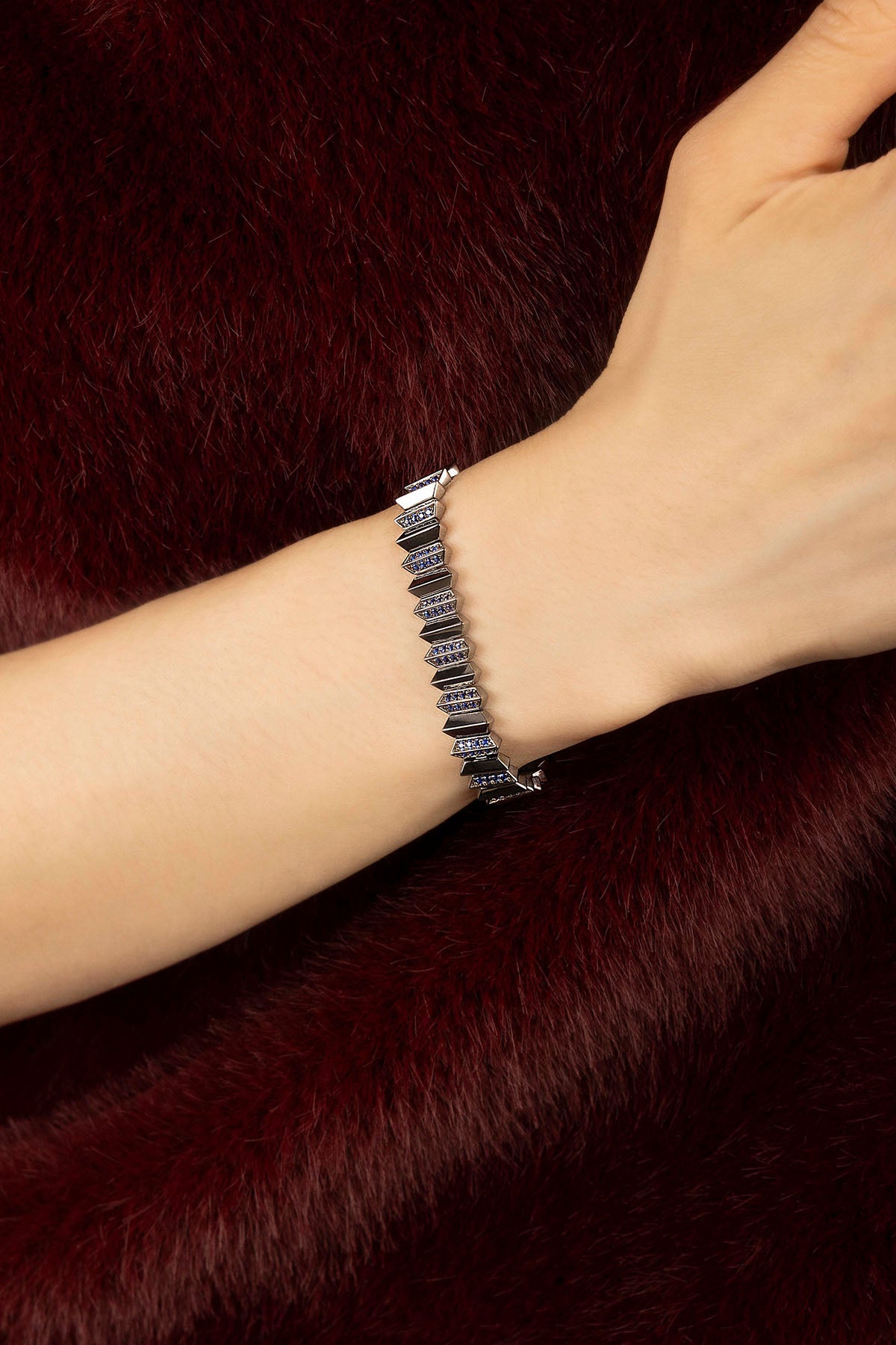 Woman wearing APM bracelet, sculpted arrows in rhodium finish, quietly bold.