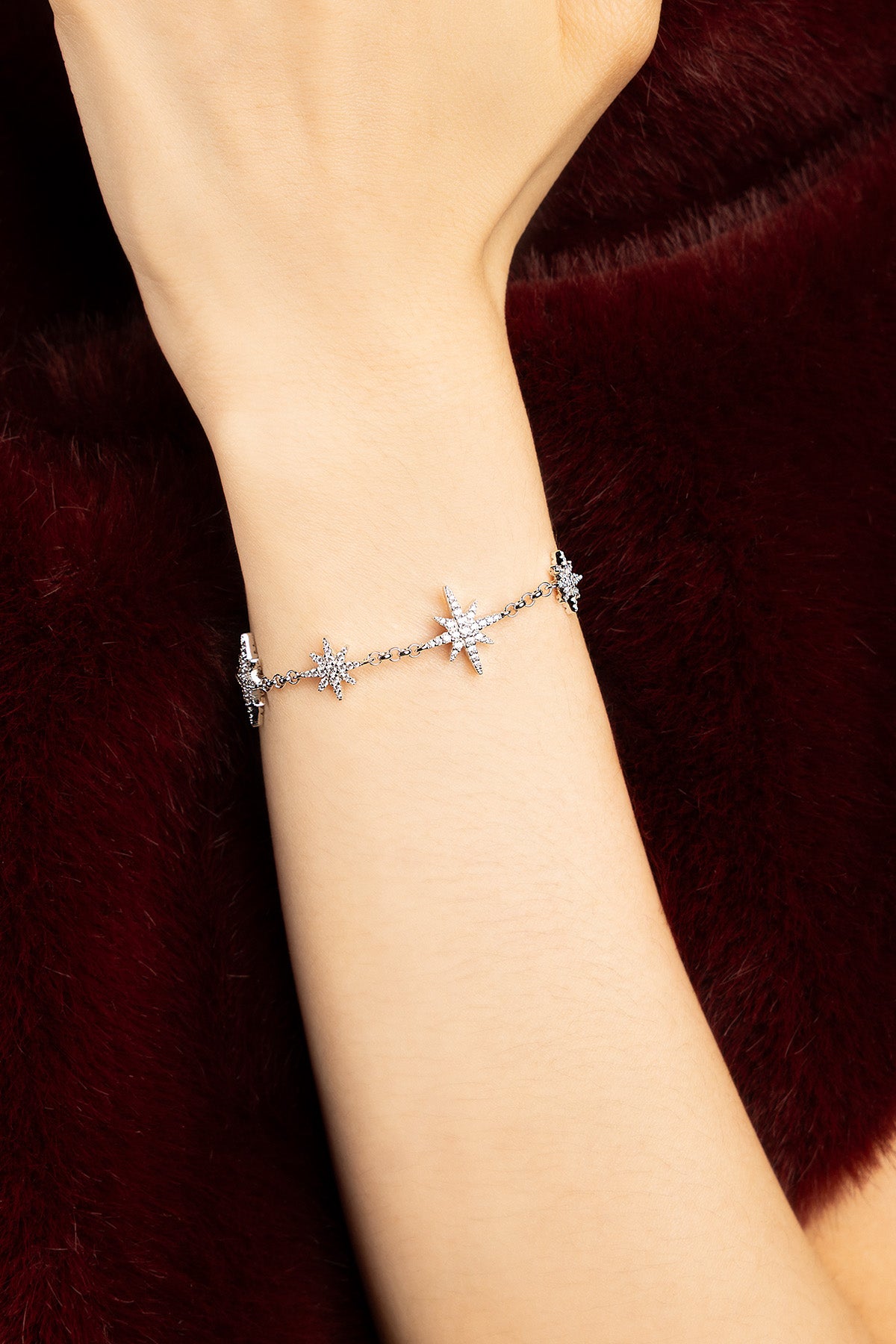 Woman wearing APM Météorites Bracelet, a constellation of light against velvet.