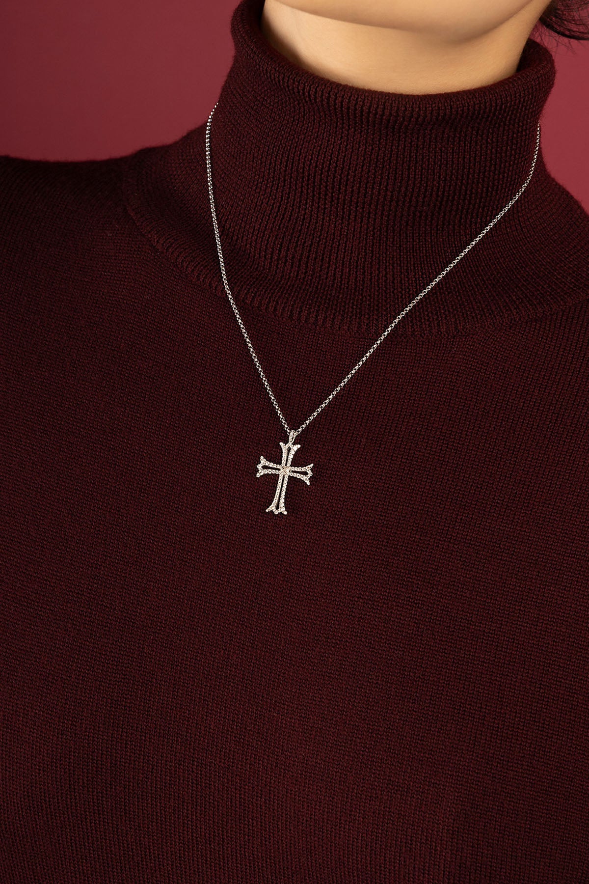 Woman wearing APM cross pendant necklace, a quiet emblem of timeless grace.