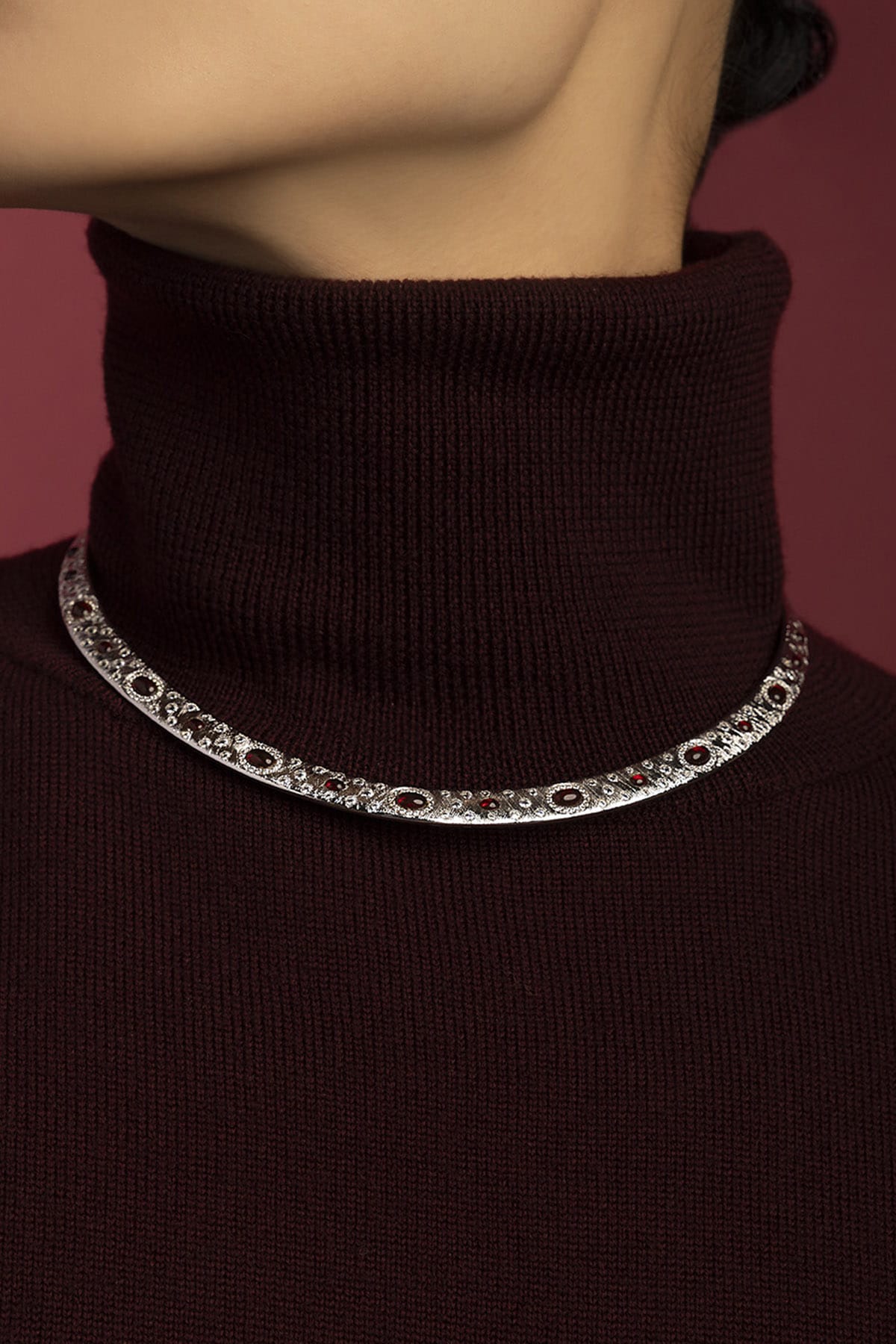 Woman wearing APM Monaco necklace, rhodium finish glowing with crimson allure.