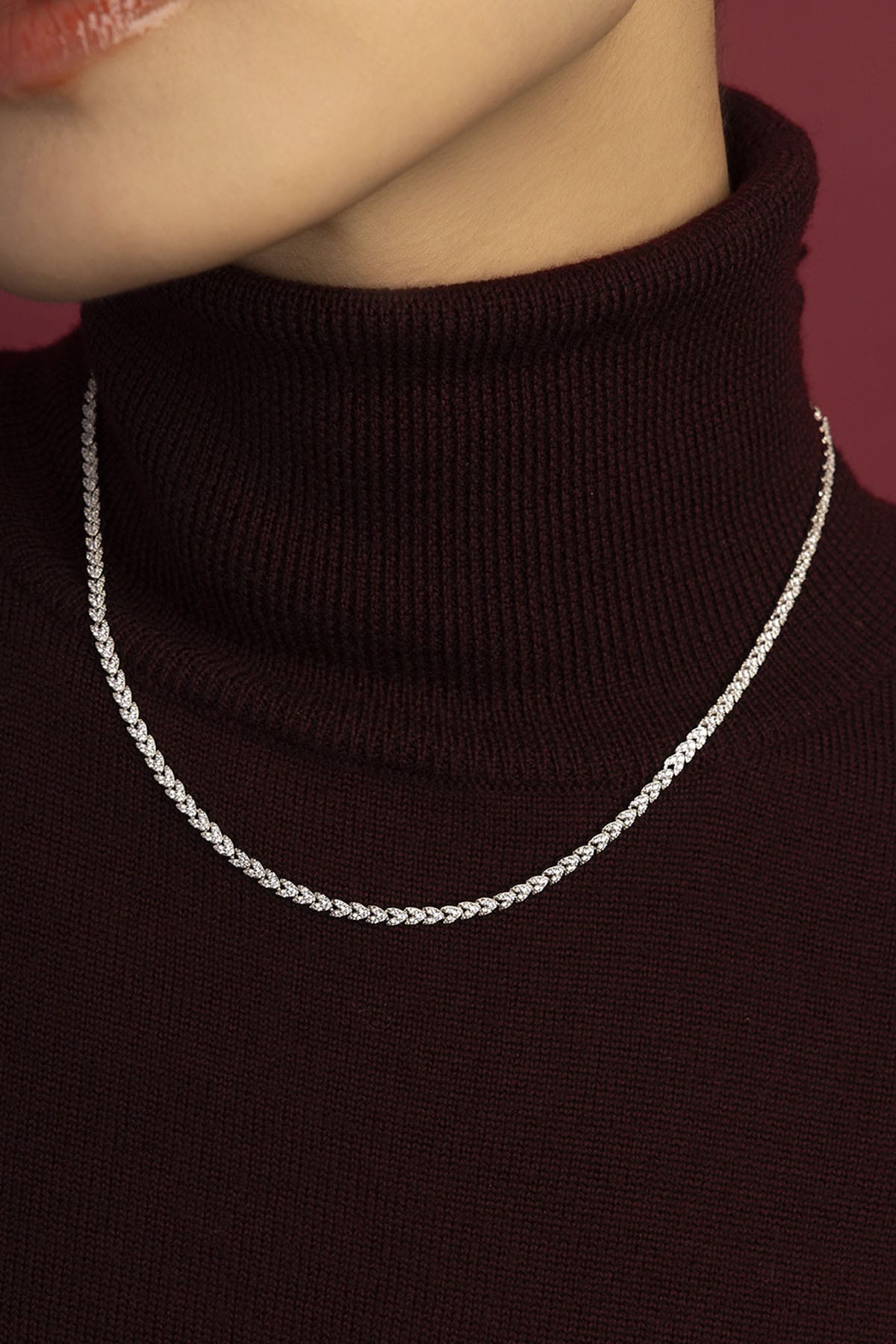Woman wearing APM Monaco chain necklace, a shimmering line of quiet confidence.
