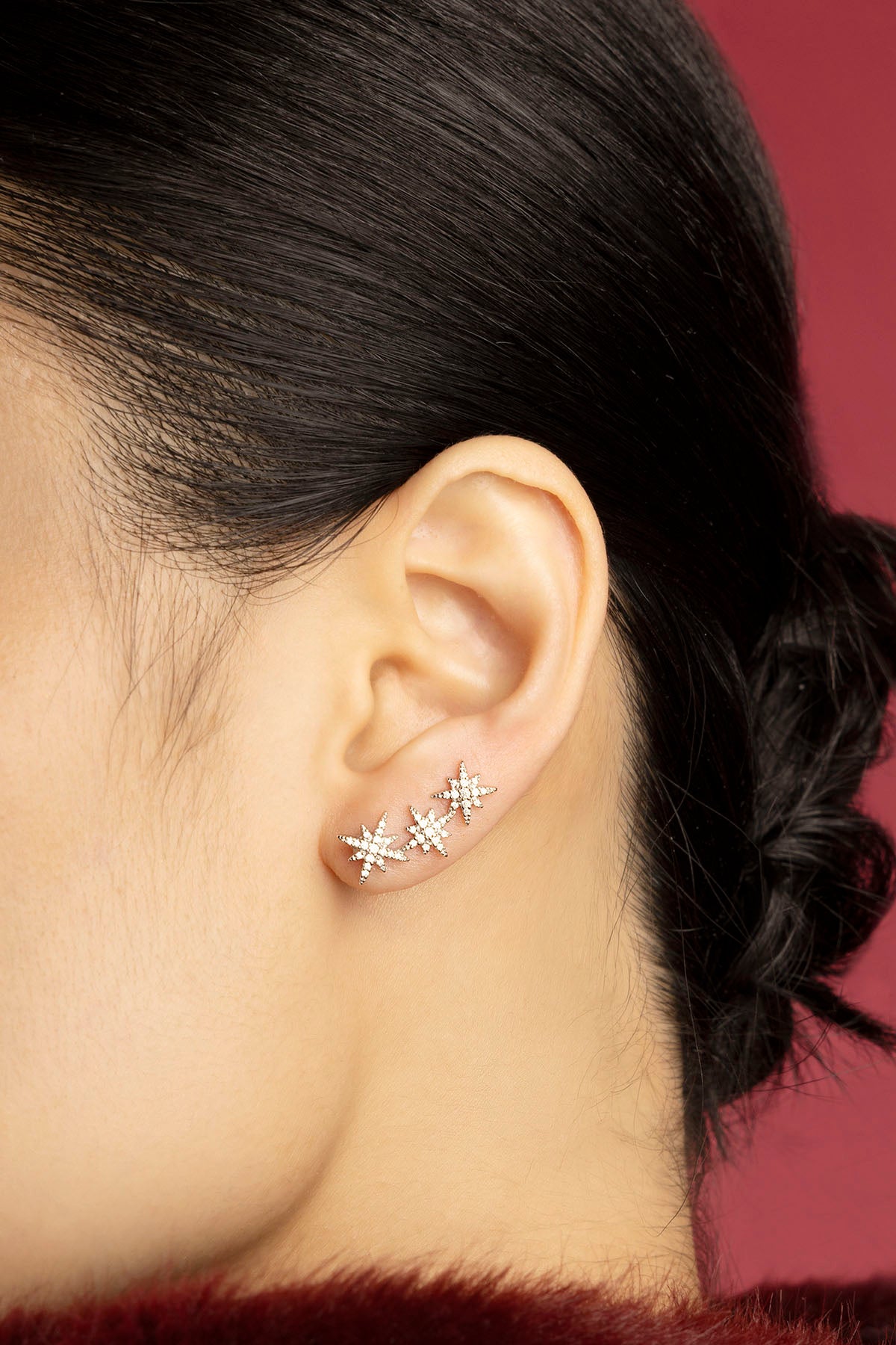 Woman wearing APM Météorites earrings, a constellation of stars tracing quiet elegance.