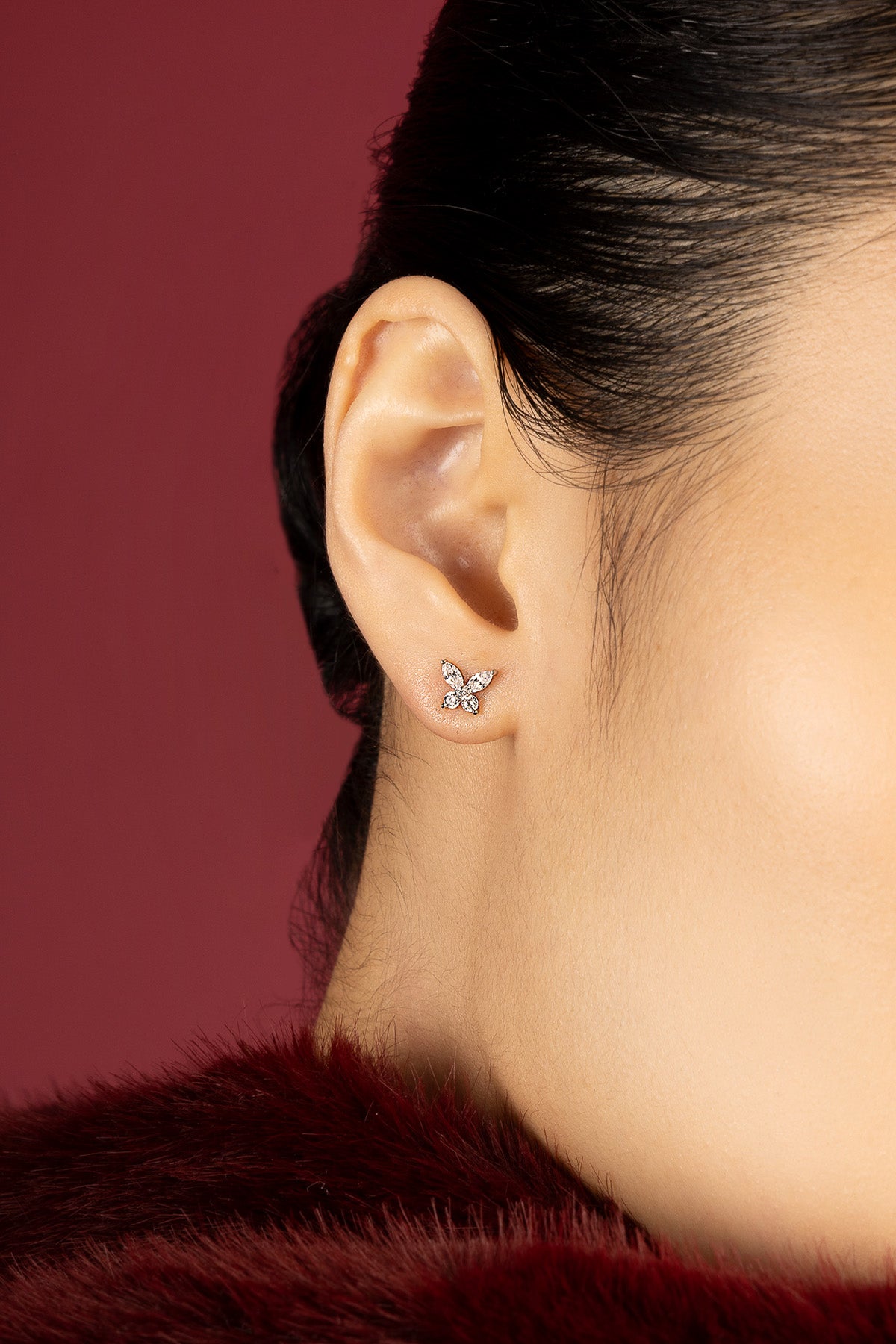 Woman wearing APM butterfly earrings, a delicate flutter of quiet elegance.