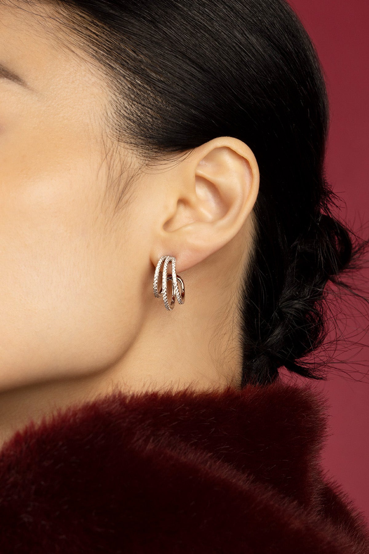 Woman wearing APM hoop earrings, a whisper of intertwined elegance.