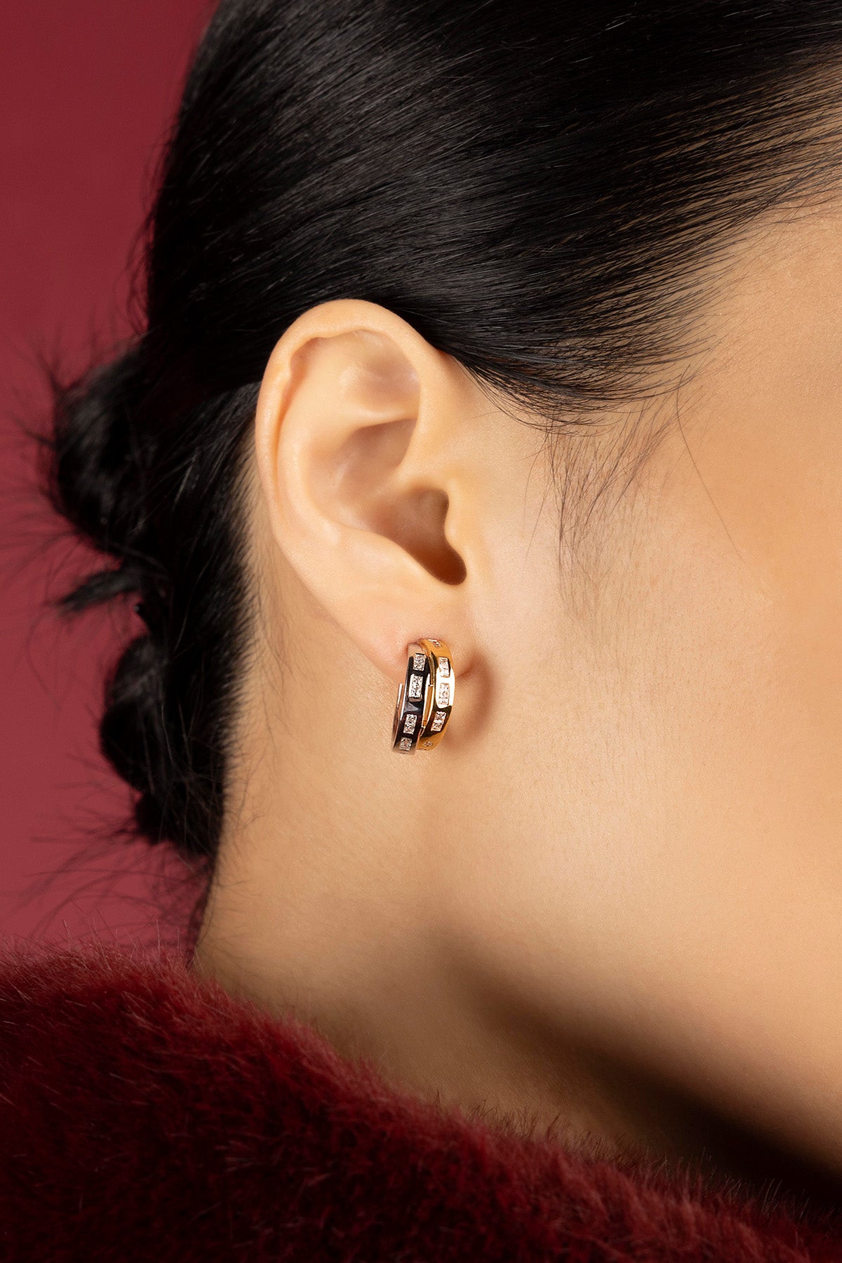 Woman wearing APM Monaco hoop earrings, a golden glow of quiet confidence.