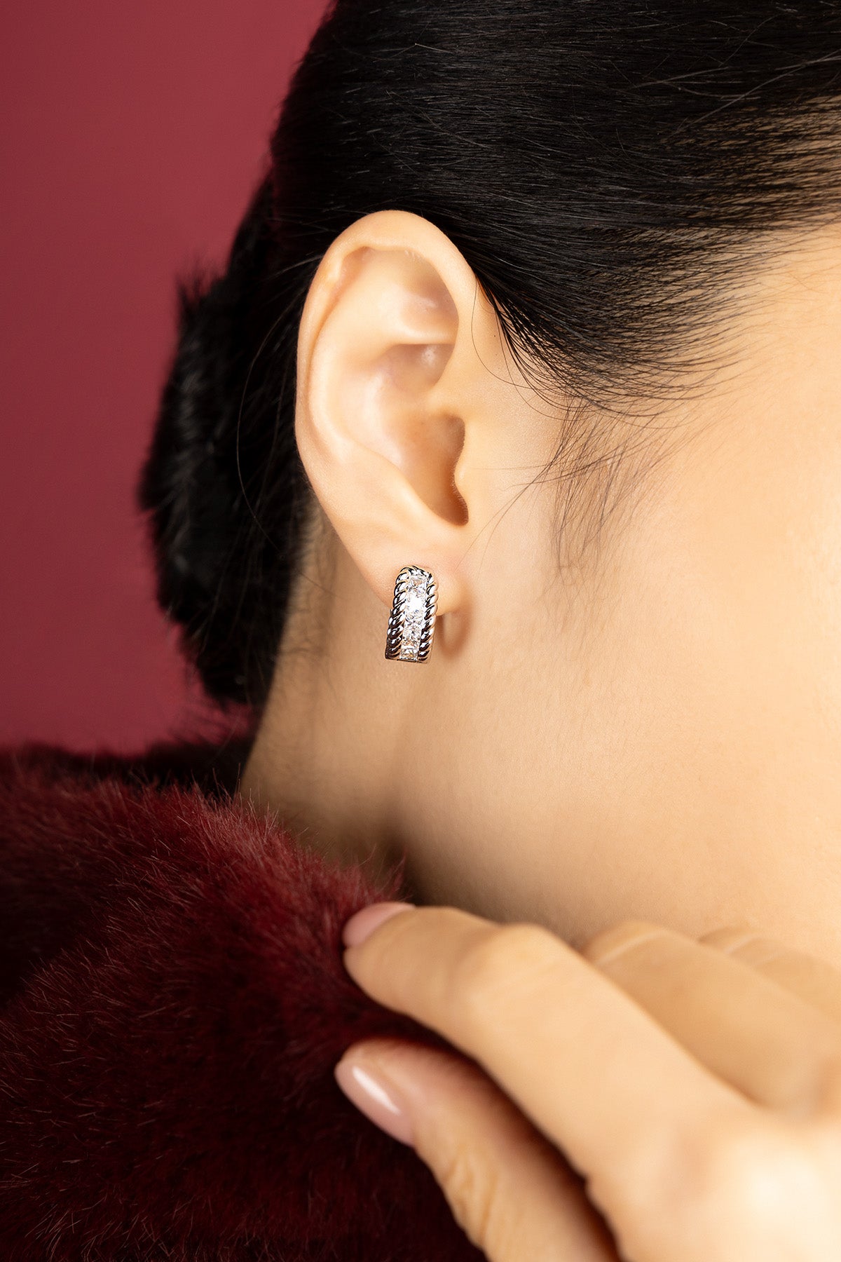 Woman wearing APM Monaco hoop earrings, a whisper of bold elegance.