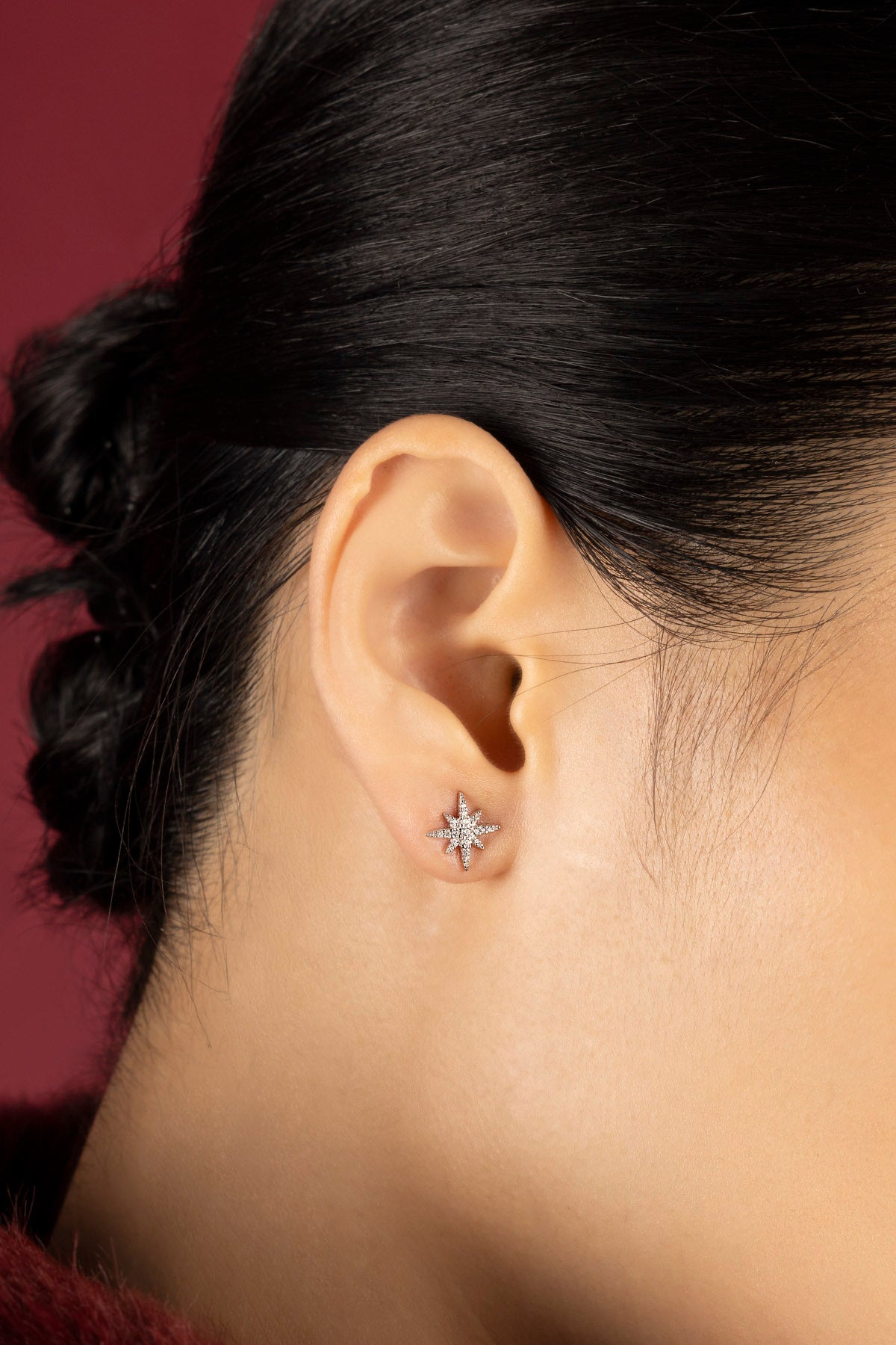 Woman wearing APM star stud earrings, a quiet sparkle of celestial charm.