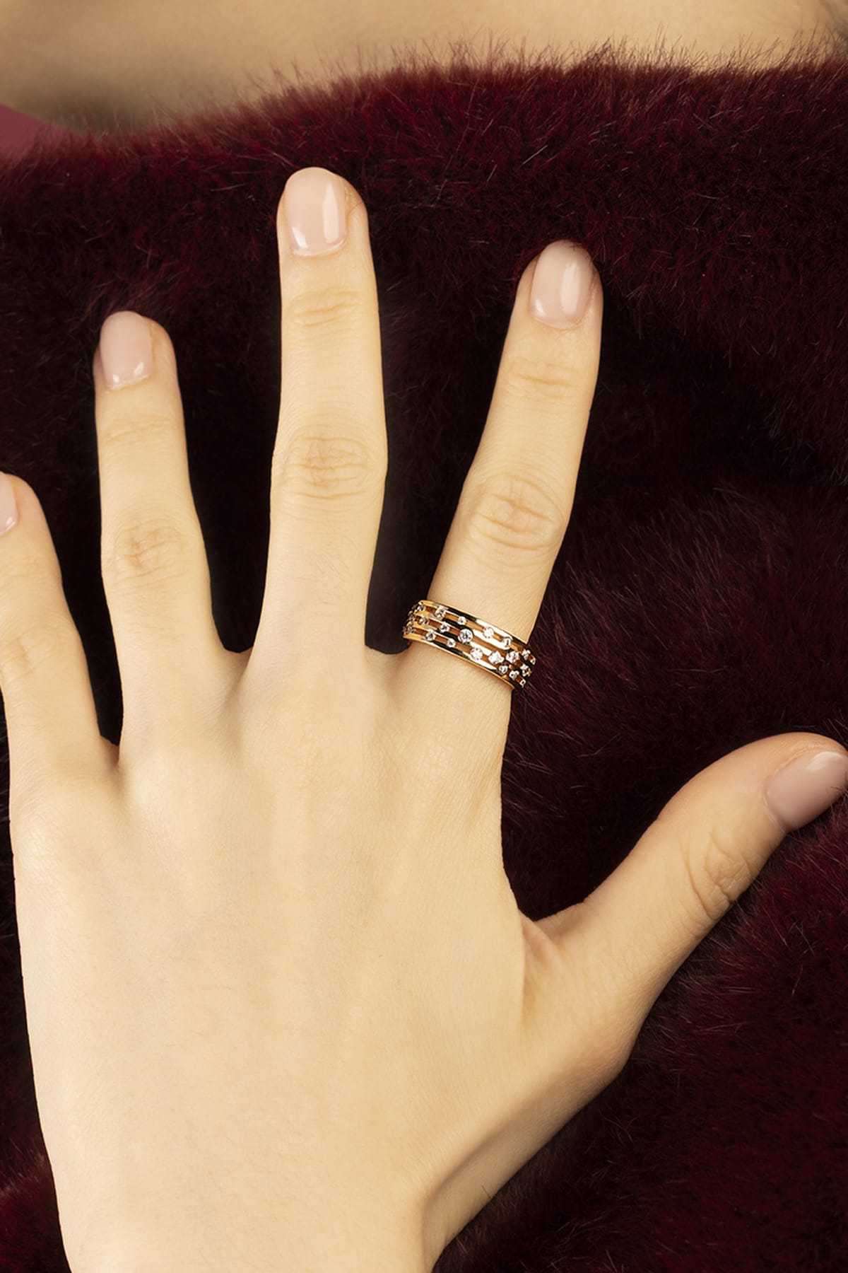 Woman wearing APM Ring, delicate rose glow scattered with sparkling stars.