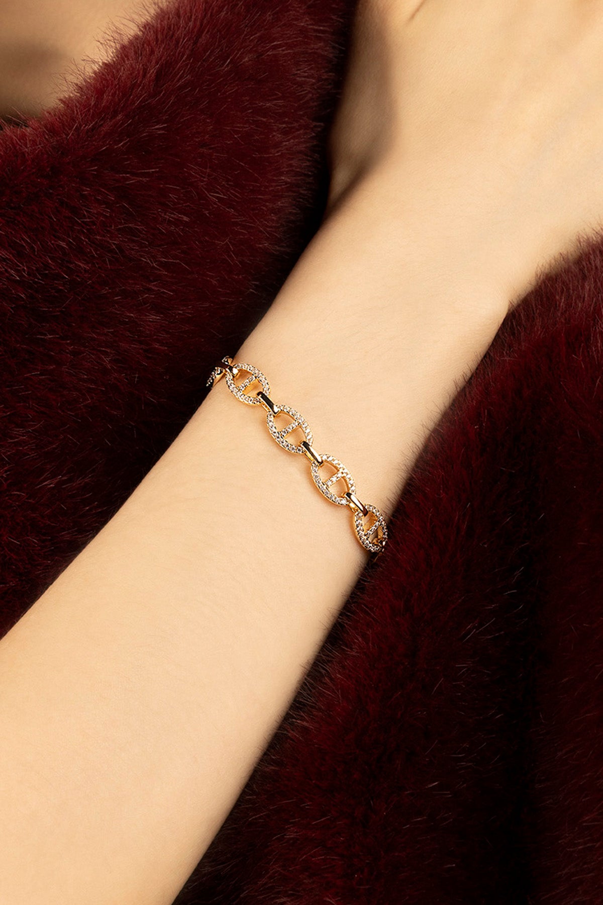 Woman wearing APM Monaco chain bracelet, a golden whisper of quiet confidence.