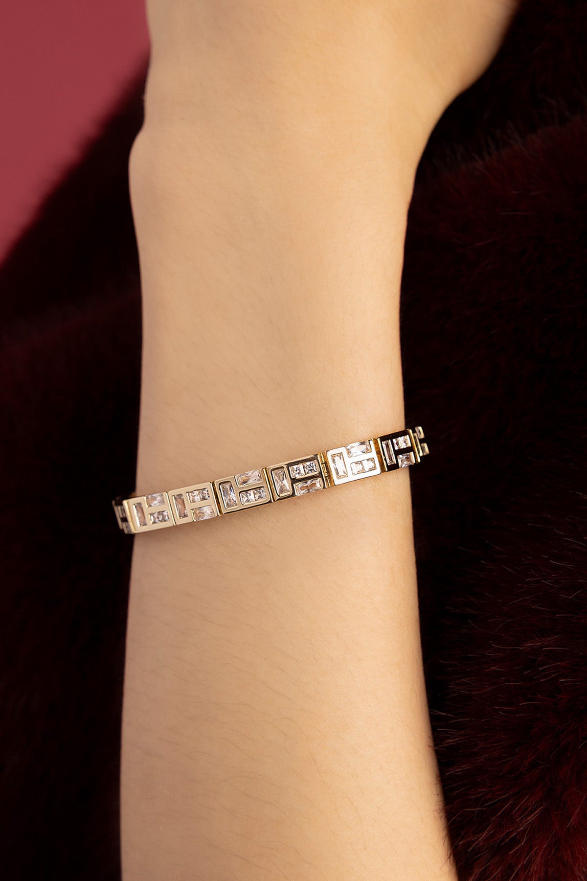 Woman wearing APM Monaco bracelet, a luminous geometric statement in rhodium finish.