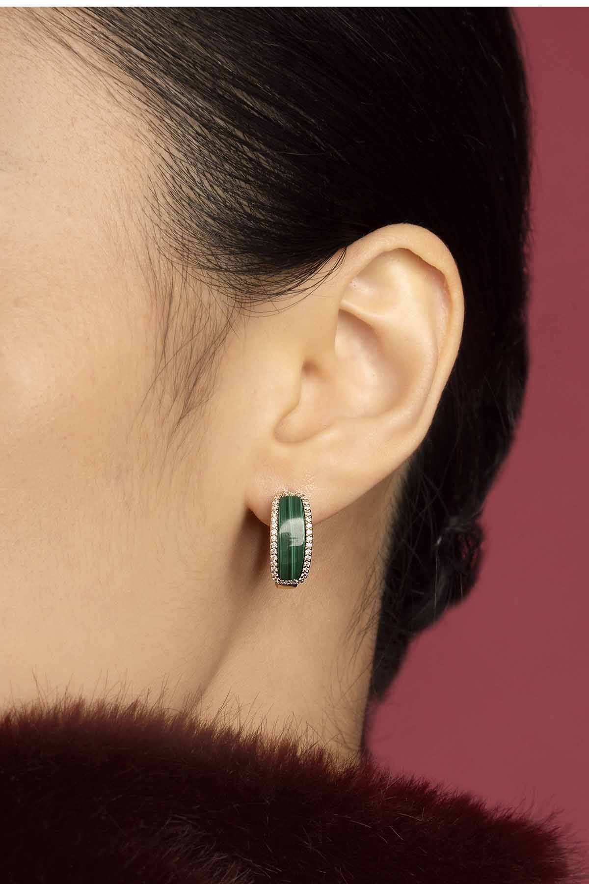 Woman wearing APM Earrings, a bold green stone framed in quiet elegance.