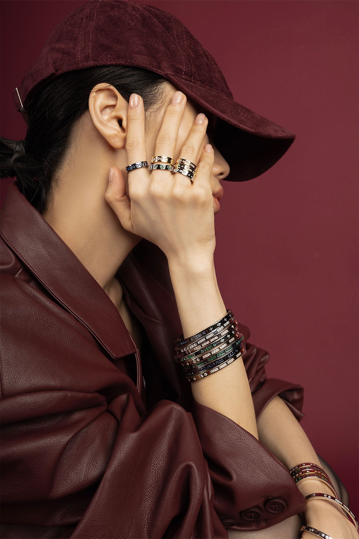 Woman wearing APM stacked rings and bangles, a bold burgundy statement of effortless allure.