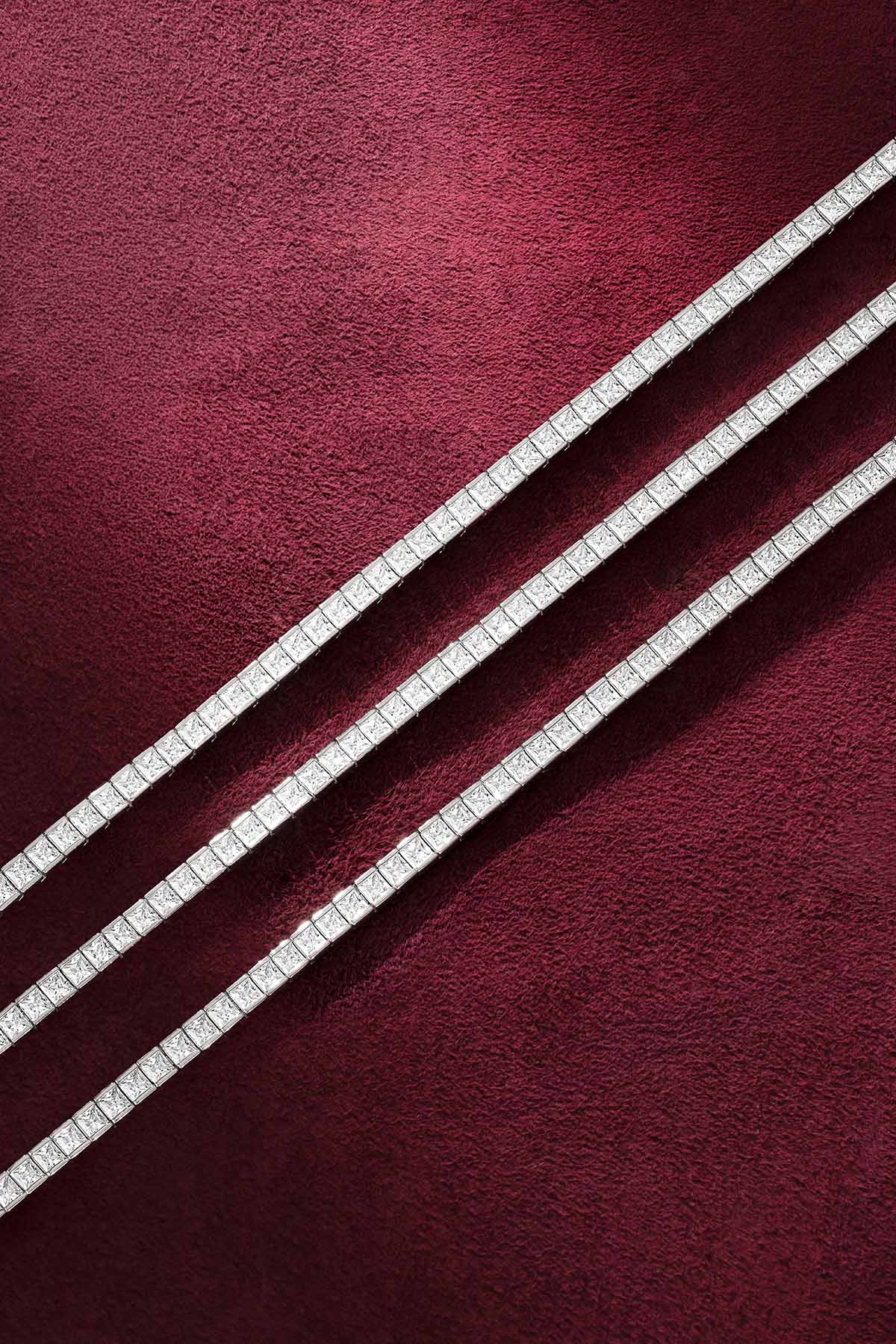 APM tennis bracelets in rhodium finish, aligned with quiet radiance on velvet.