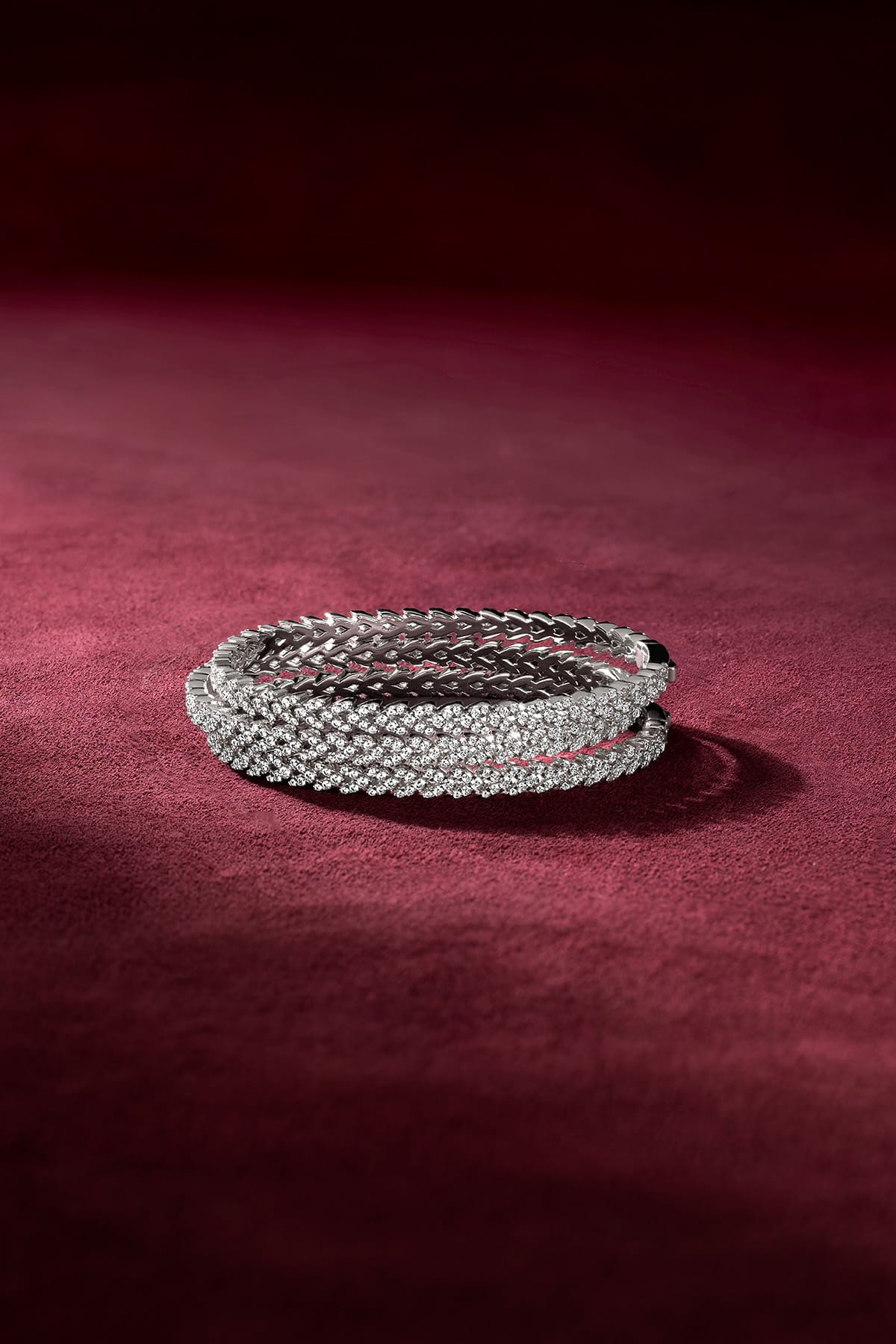 APM Monaco bangles in rhodium finish, sparkling with quiet confidence on velvet.