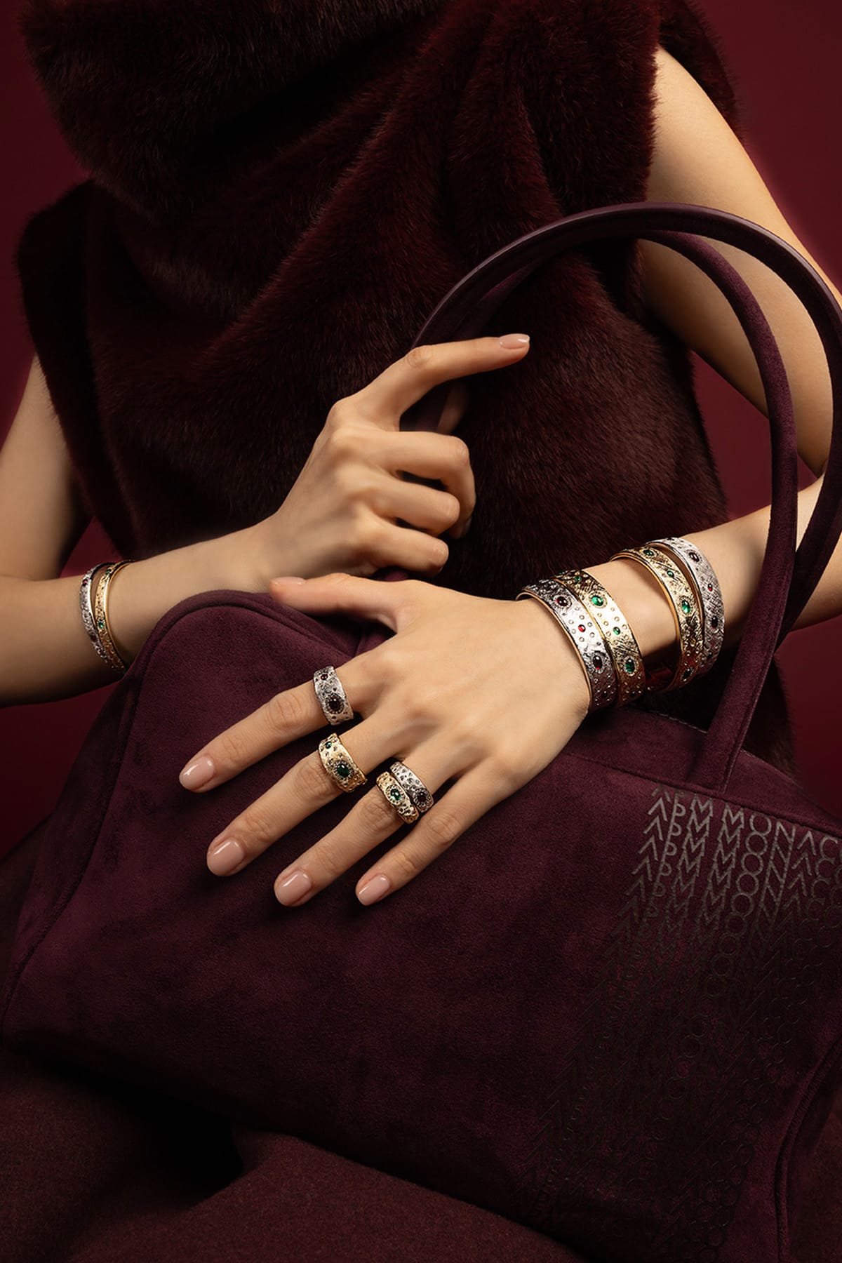Woman wearing APM Bangles and Rings, a jewel-toned reverie in rich burgundy elegance.