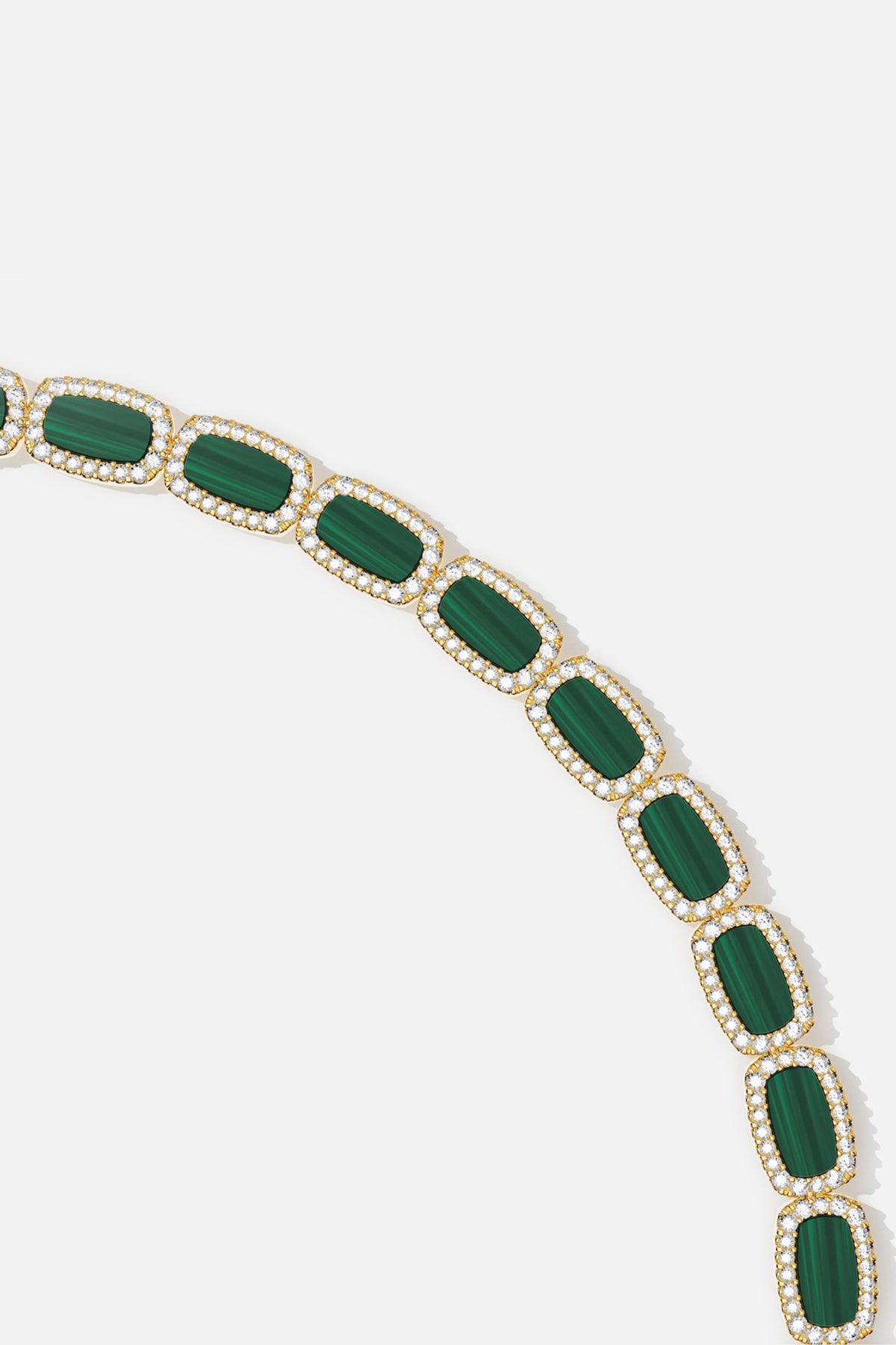 APM Monaco bracelet, emerald green stones glowing within a luminous gold cascade.