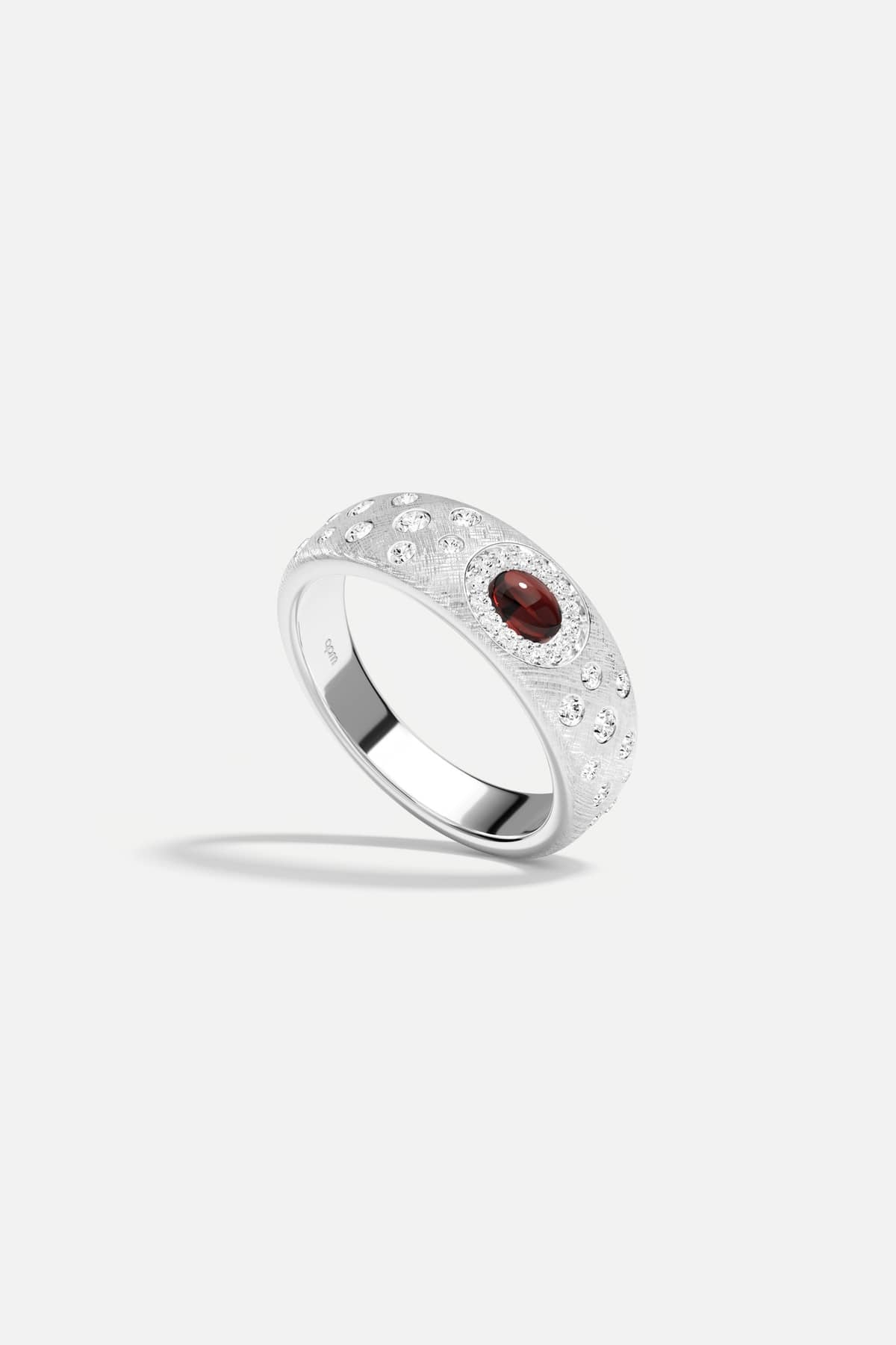 APM Ring in rhodium finish, a deep red glow whispering quiet elegance.