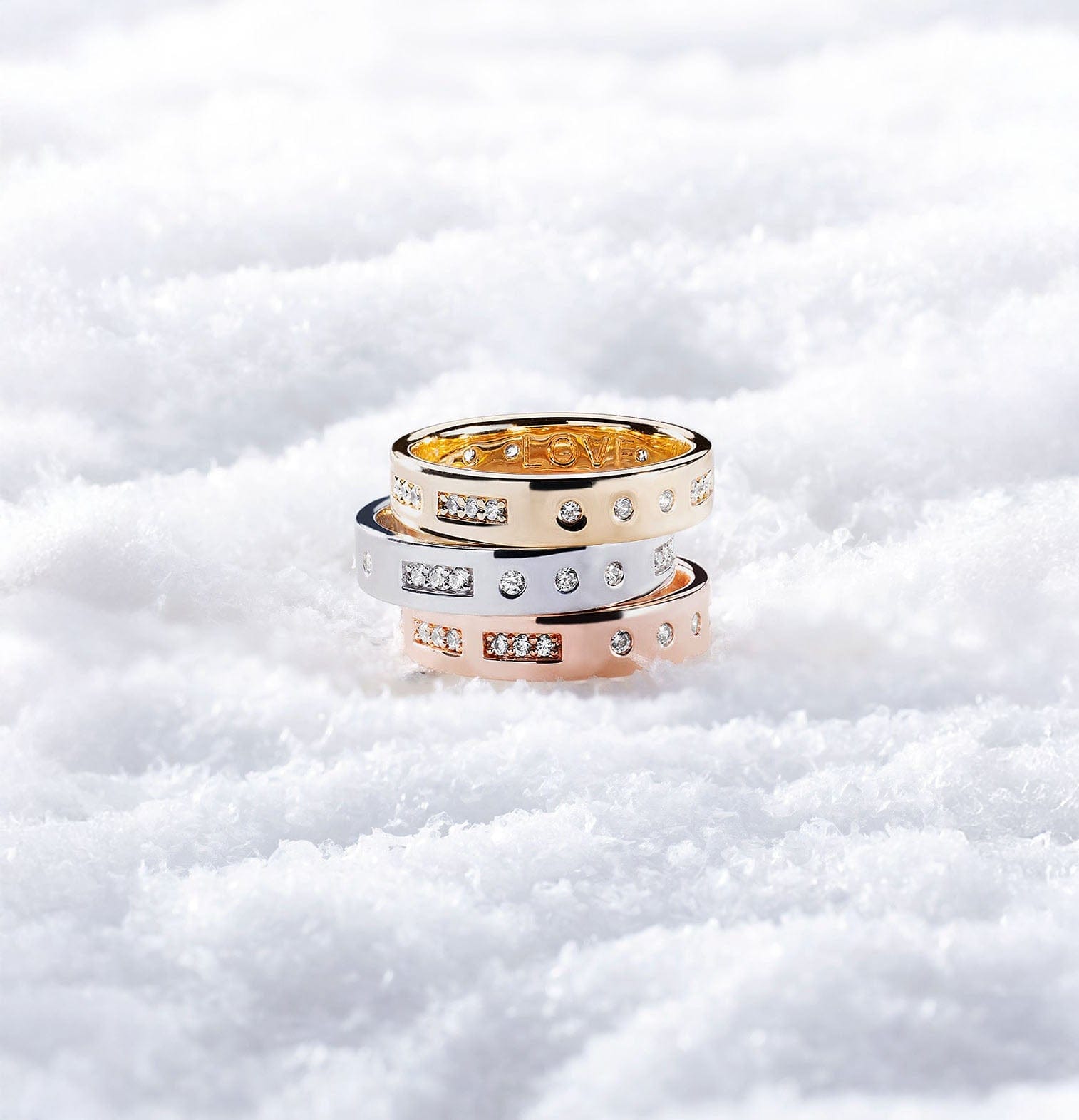 Three APM MONACO morse code rings stacked on a snowy background