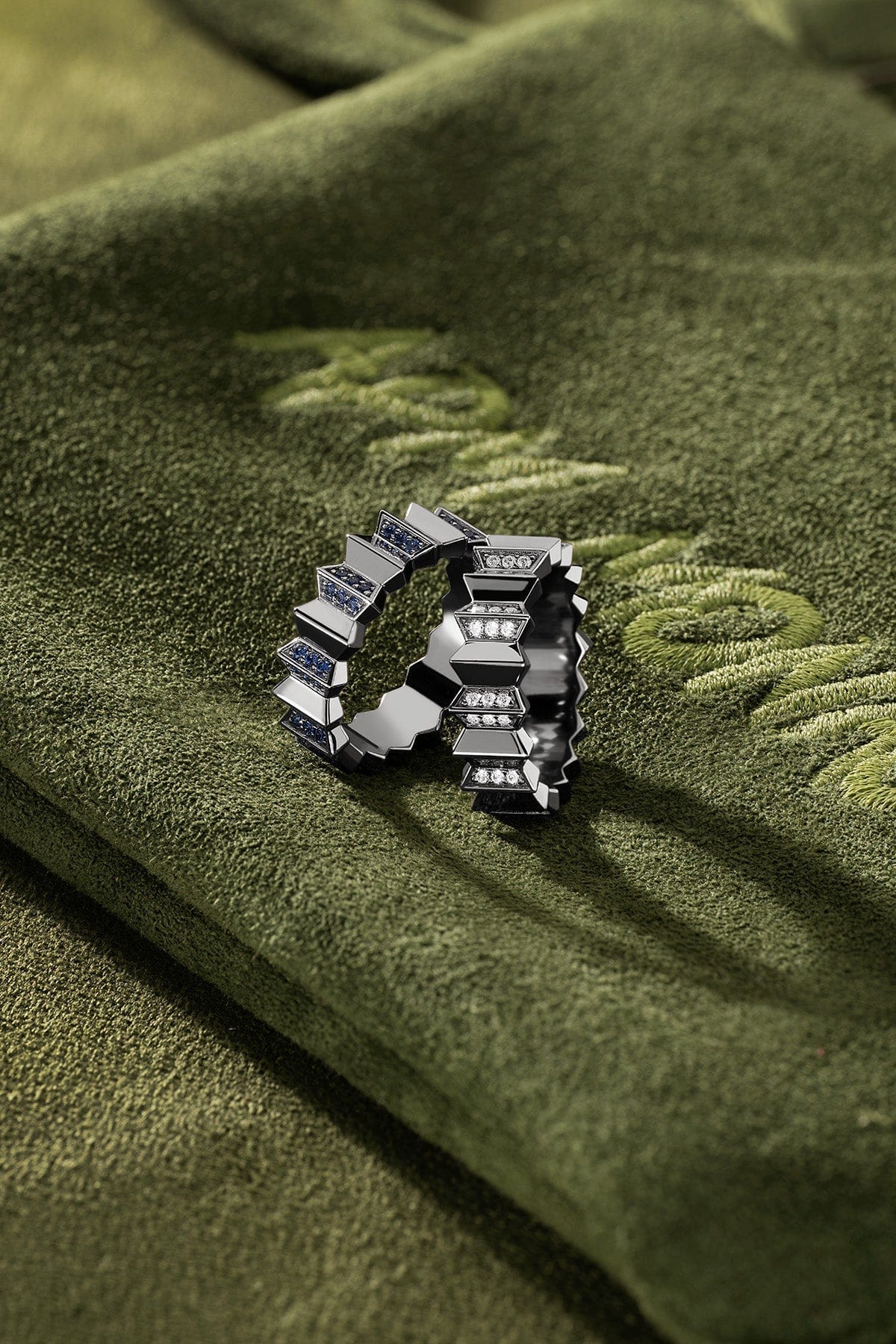 APM Monaco Up and Down Ring in dark grey on a green fabric background